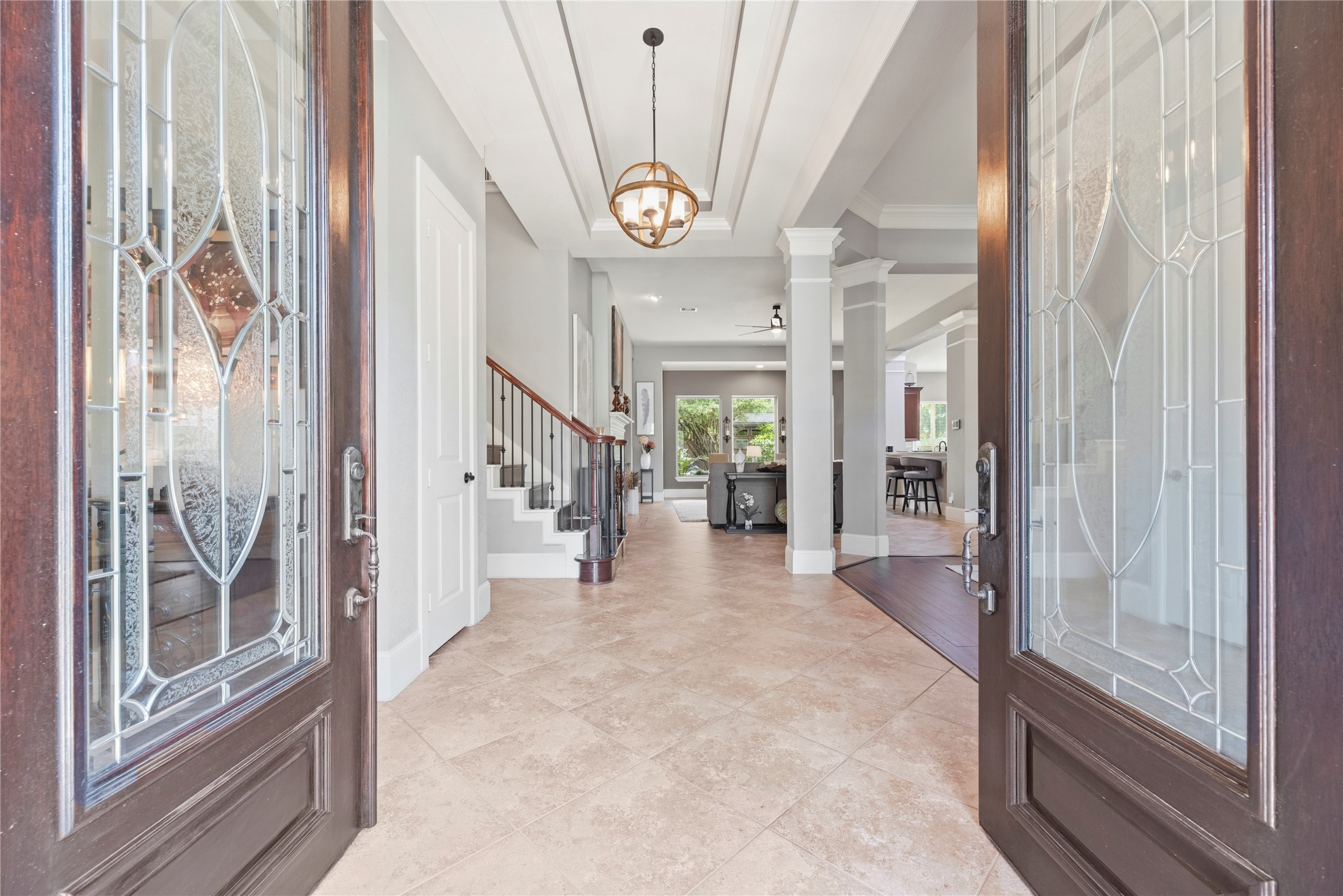 Wood double door entryway, coffered ceilings, and beautiful fixtures create a grand arrival experience.