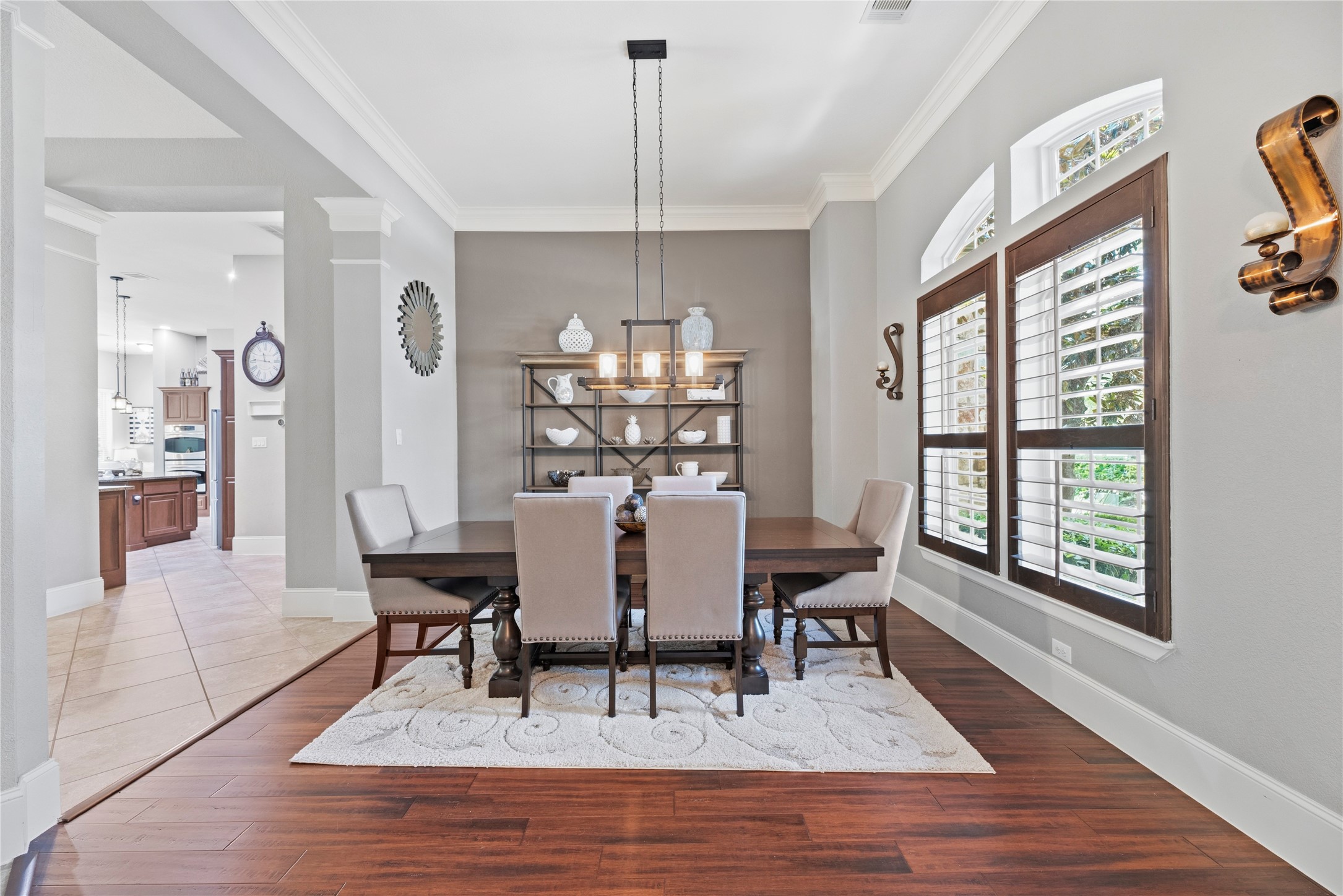 Host the next dinner party with confidence with this classy formal dining space. Featuring plantation shutters, crown molding, and an elegant light fixture.