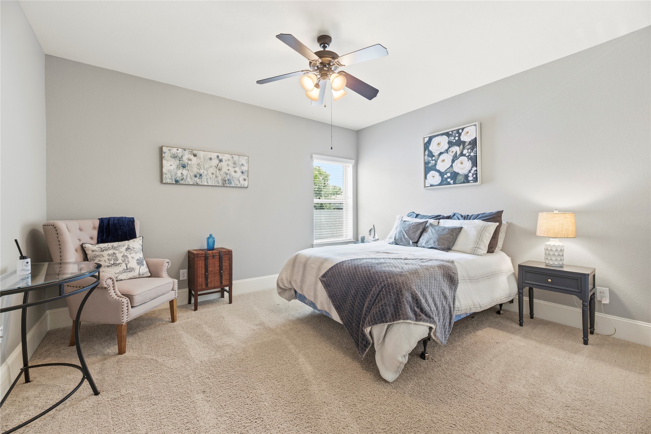 Generously sized secondary bedroom suite with plush carpet, ceiling fan and walk-in closet.
