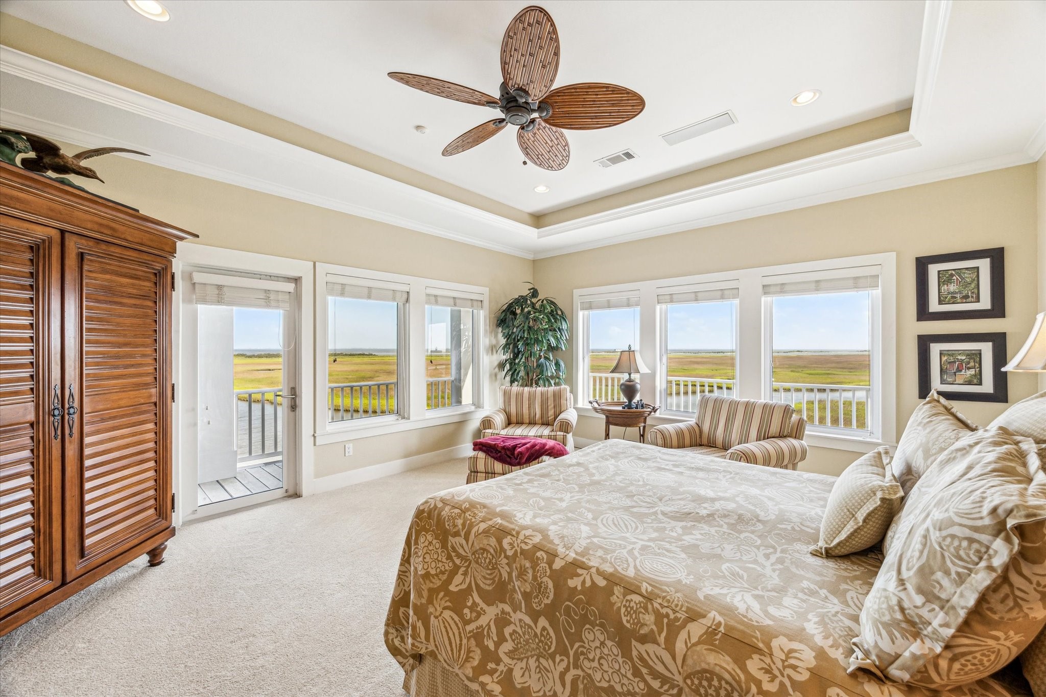 Expansive windows flood in natural light and showcasing unobstructed views of the bay and wetlands while direct access to the balcony enhances the indoor-outdoor living experience