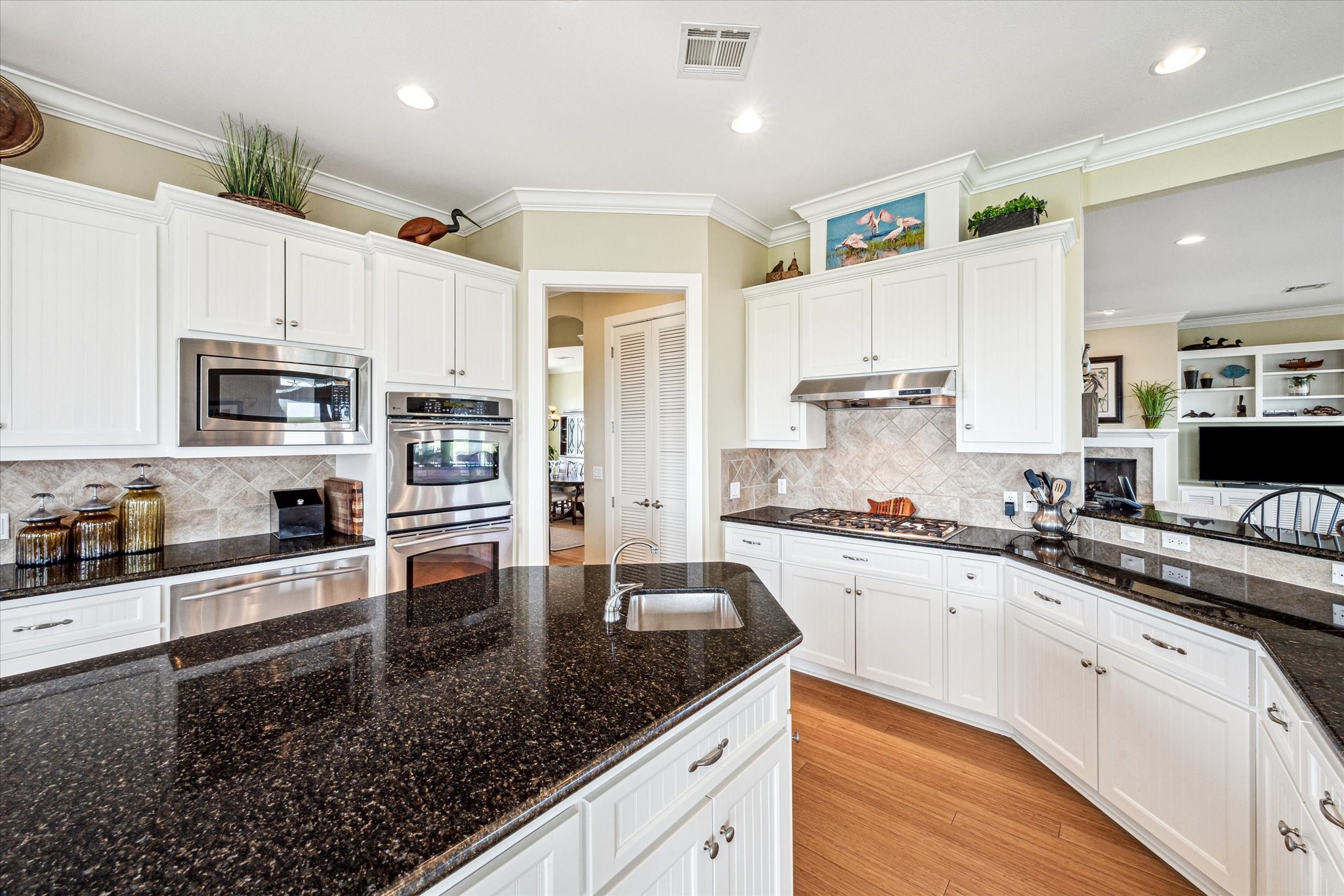 At the center, a large island with a built-in prep sink provides the perfect workspace for cooking and entertaining