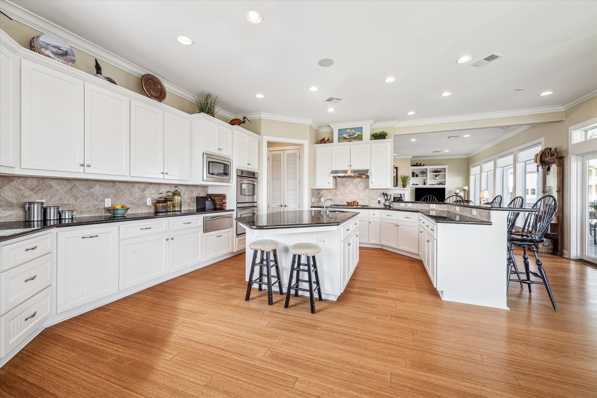 The kitchen is open to the family room, creating a seamless flow for everyday living and entertaining. It features soft-closing cabinets and drawers, undercabinet lighting for added ambiance and functionality, and a spacious walk-in pantry that offers ample storage