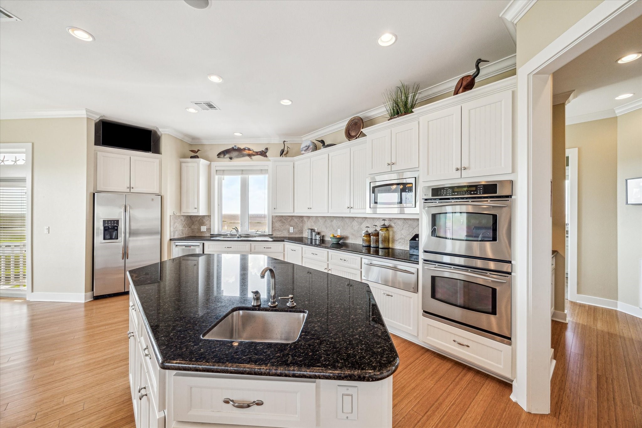 This spacious gourmet kitchen is thoughtfully designed for both functionality and style, featuring expansive granite countertops, top-of-the-line stainless steel appliances, and custom cabinetry that offers ample storage