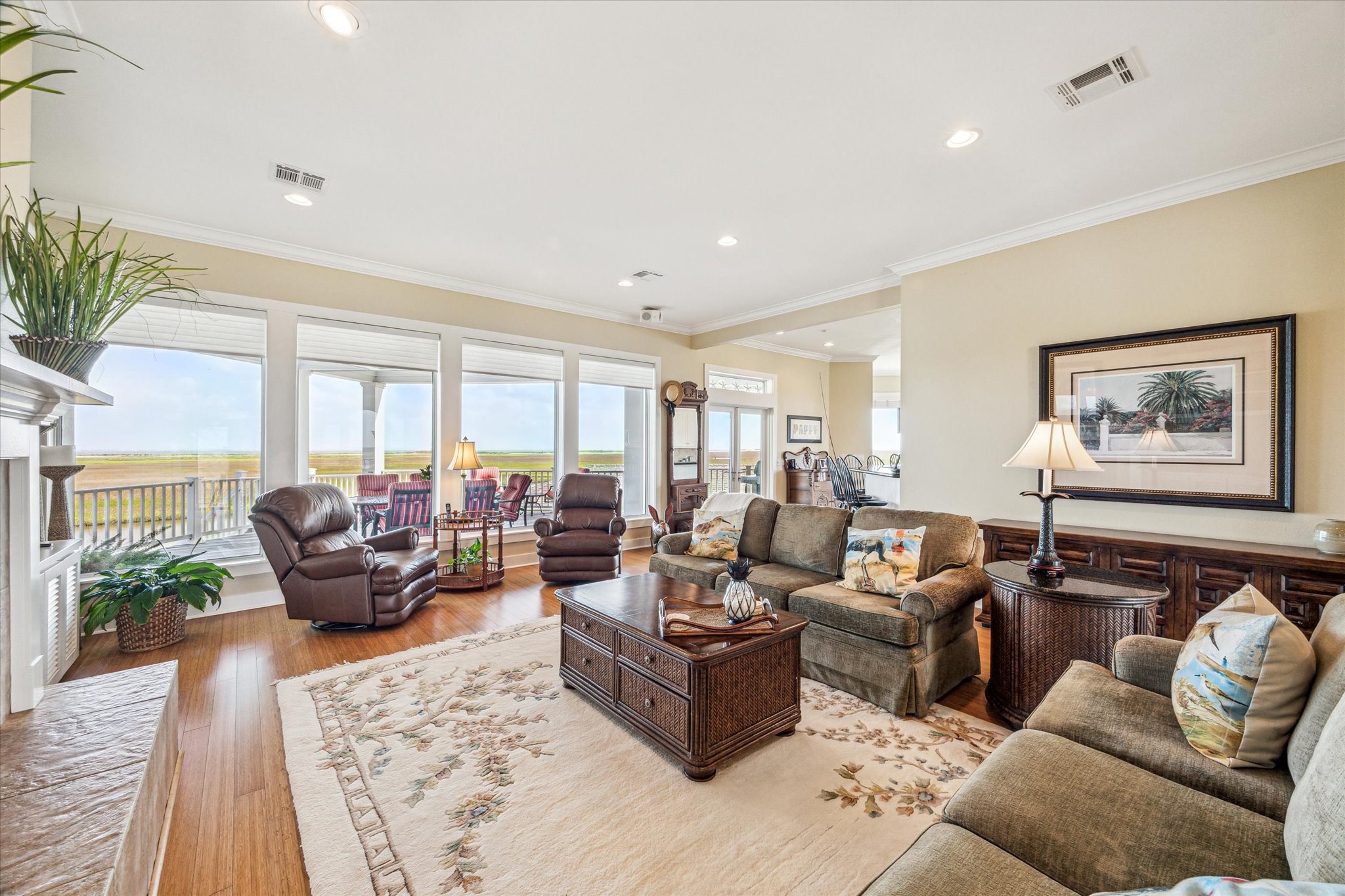 An elegant living space showcasing timeless design and modern comfort, featuring bamboo floors and tile throughout the main level for both style and durability. A wall of windows offers endless views from the comfort of your home, or step out onto the covered deck to take it all in