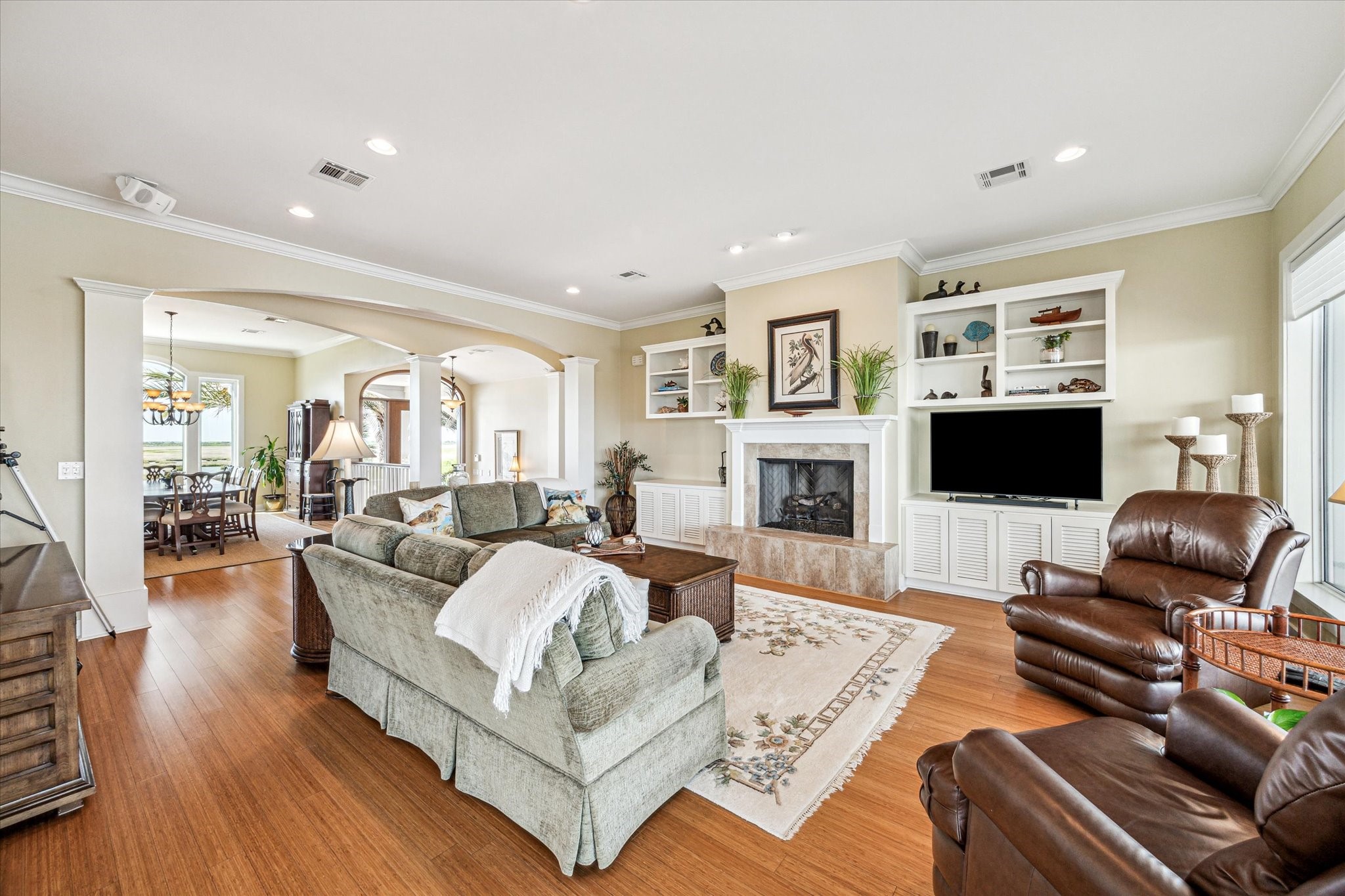 A 42" wood burning fireplace with gas log and custom built-in entertainment center anchor the space, which flows effortlessly into the kitchen and dining areas. Ceiling fans in every room enhance airflow and comfort, creating a welcoming environment for everyday living and entertaining