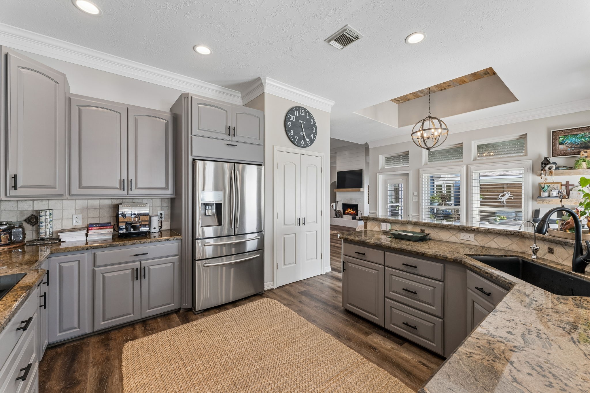 Thoughtfully designed kitchen offers abundant counter space, a large peninsula, and ample storage for effortless meal preparation. Windows overlooking the outdoor spaces bring natural light into the heart of the home.