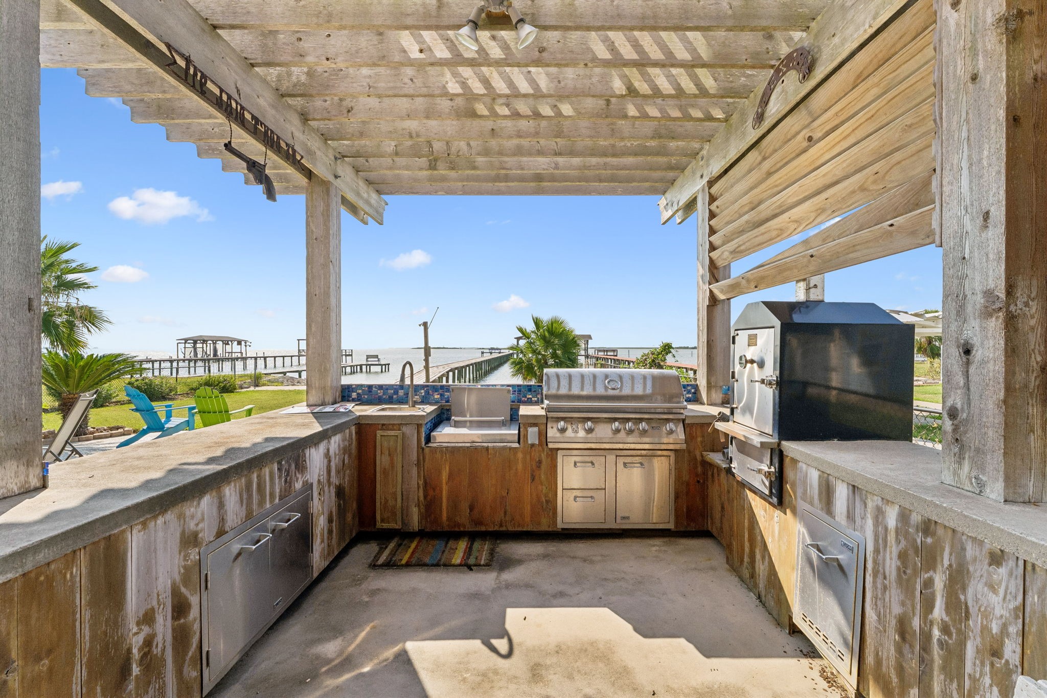 Outdoor kitchen features built in grilling and cooking stations with generous prep space for hosting by the water. Open views toward Galveston Bay make every cookout feel like a coastal getaway.