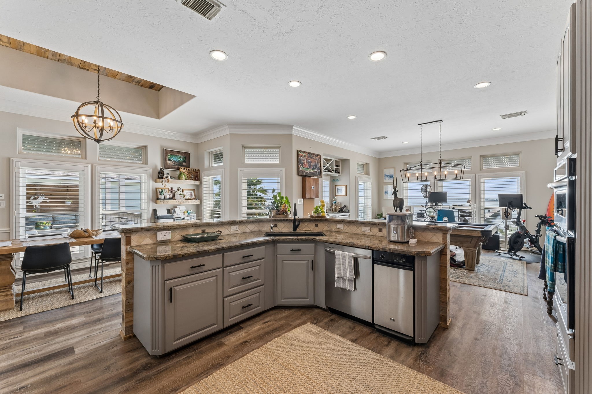 Open kitchen design creates an easy connection between cooking, dining, and recreation spaces. Expansive granite surfaces provide plenty of room for prep and serving.