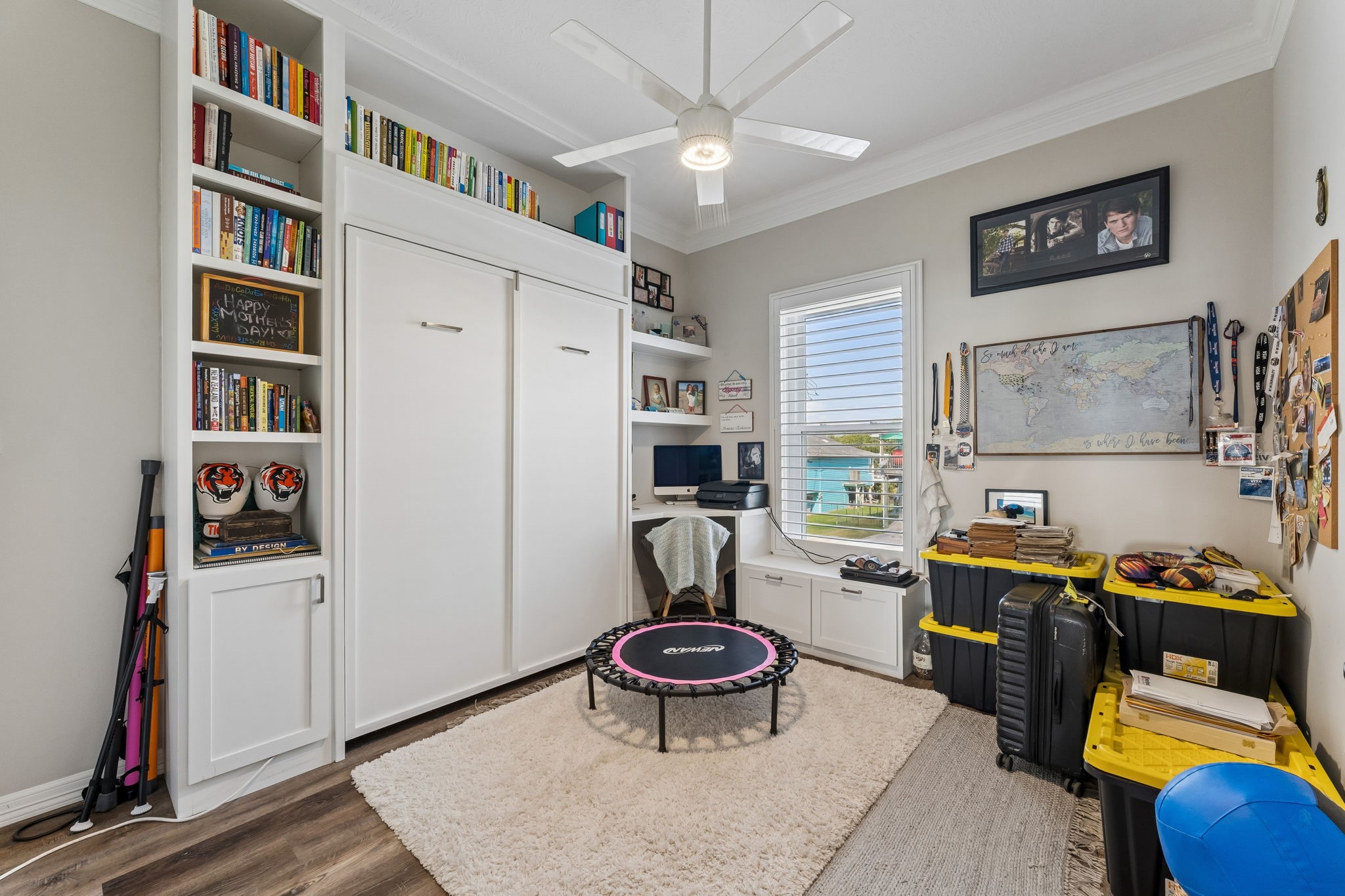 Flexible bedroom features custom built ins, integrated shelving, and a convenient workspace. Thoughtful storage maximizes functionality while keeping the room open and organized.