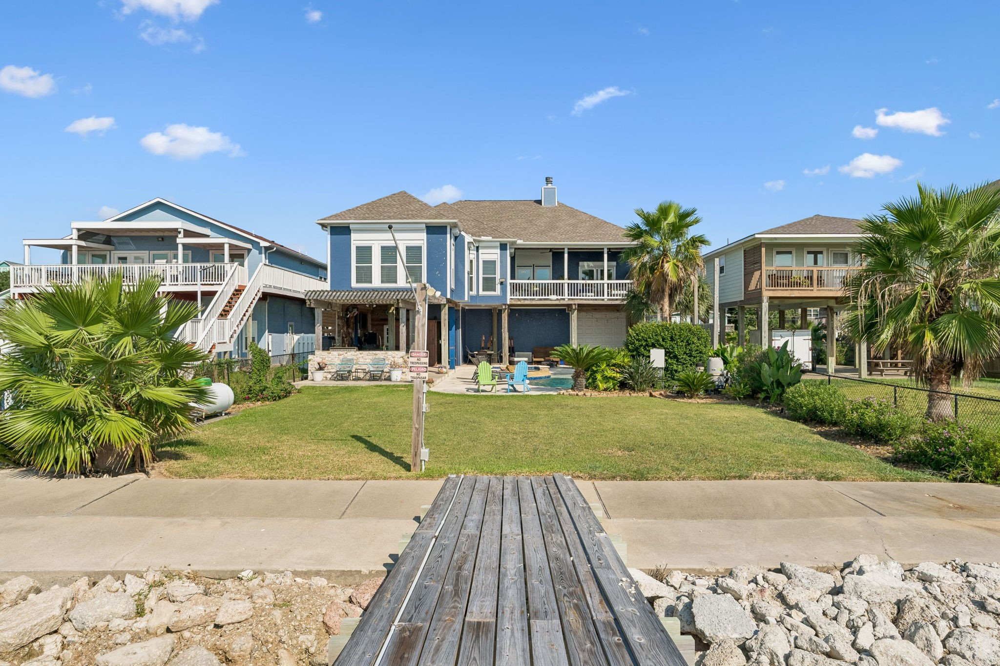 Private pier leads directly from the backyard to the waters of Galveston Bay. A generous lawn and tropical landscaping create a beautiful transition from home to waterfront.