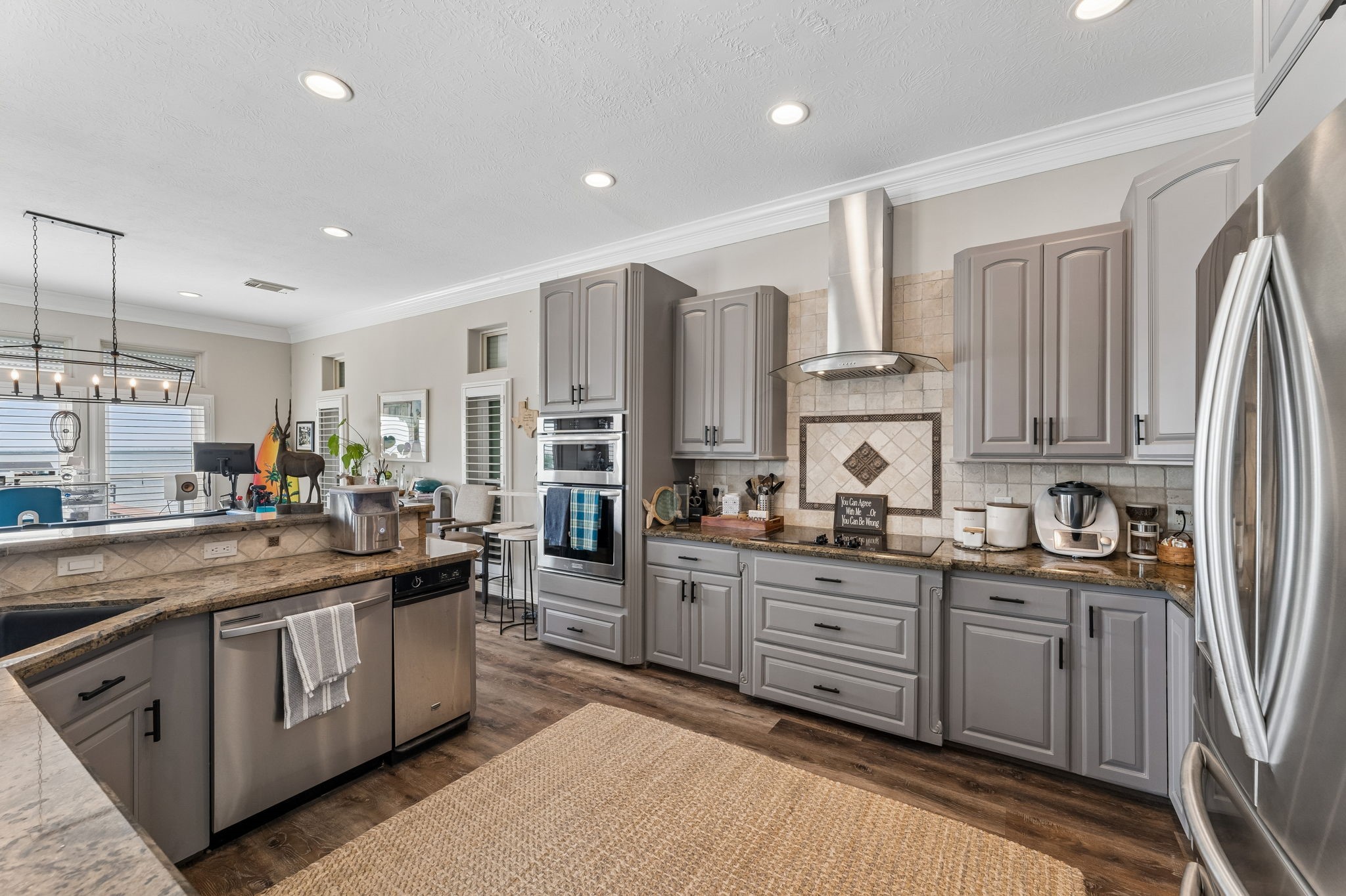 Well equipped kitchen features extensive custom cabinetry, stainless steel appliances, and generous prep space. The open design keeps the kitchen connected to the surrounding entertainment areas.