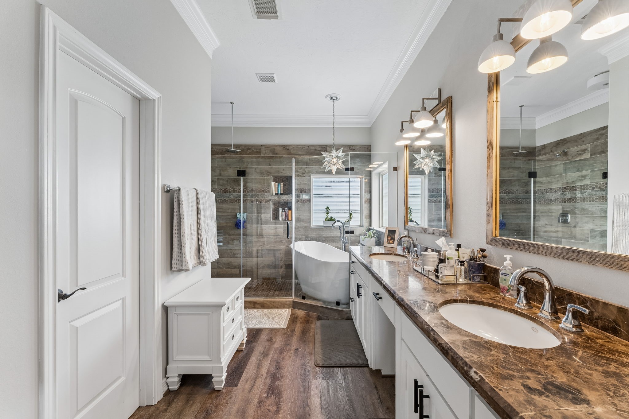 Spa inspired primary ensuite features dual vanities, rich stone countertops, and a freestanding soaking tub. The expansive wet room creates a luxurious setting for everyday relaxation.