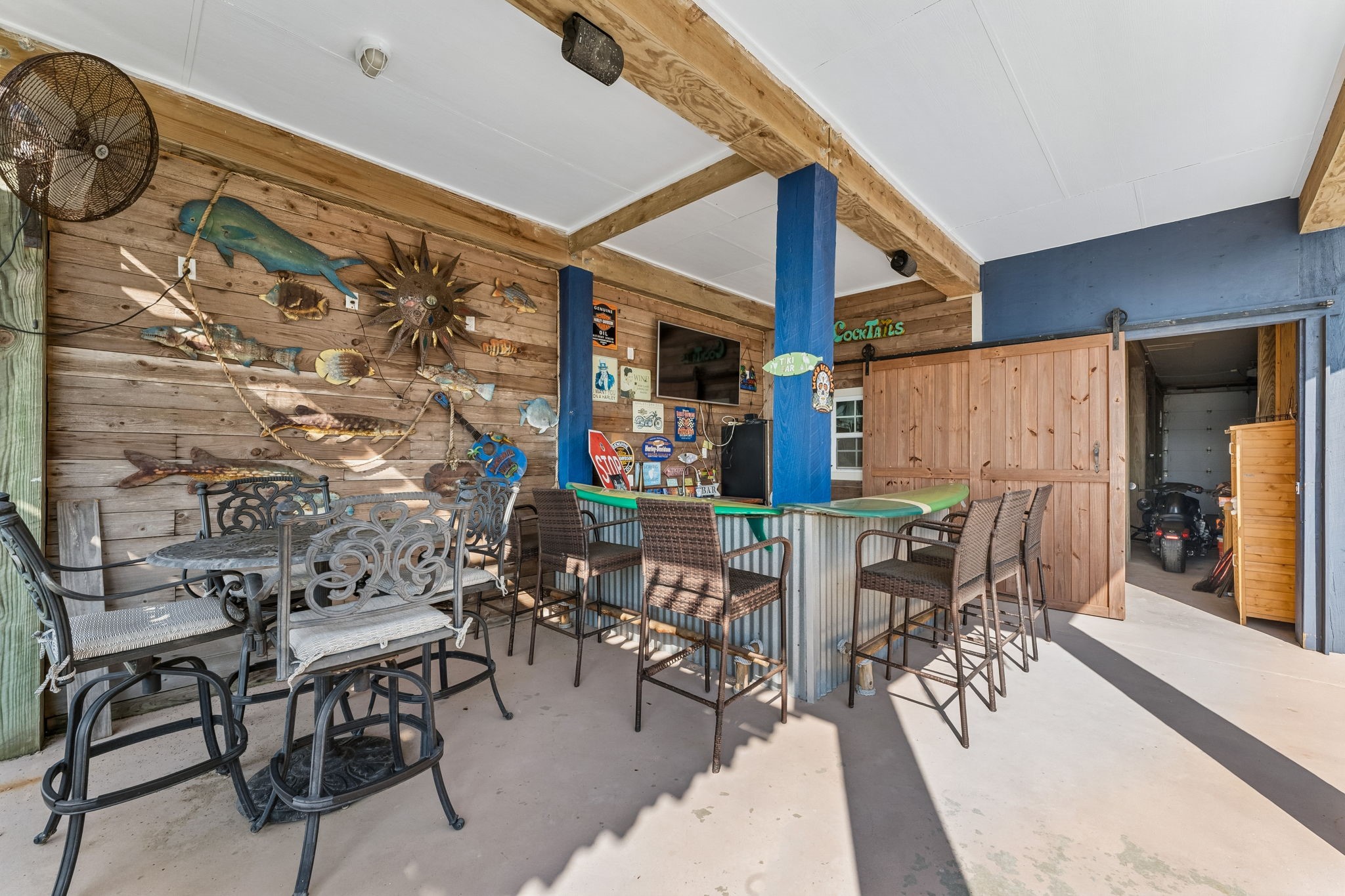 Covered entertainment area offers bar seating, a dining space, and plenty of room to gather with friends and family. Coastal inspired details give this outdoor space a relaxed waterfront personality.