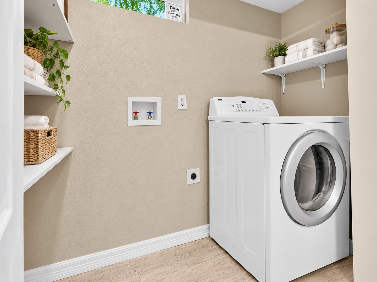 Dedicated indoor laundry area located in the second bathroom with washer/dryer connections and built-in shelving for added storage.