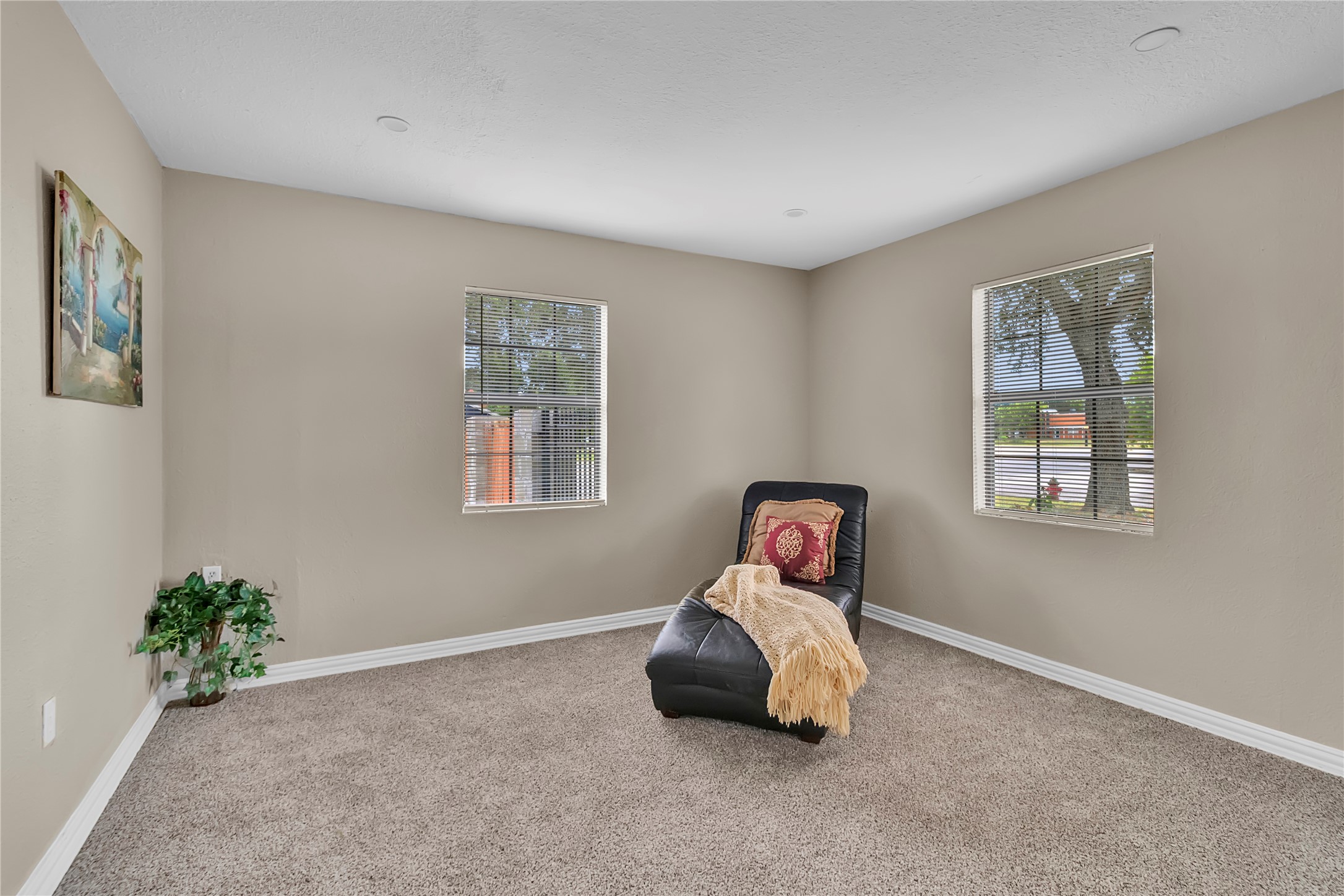 Bright and spacious 3rd bedroom with fresh carpet, and windows overlooking the property.