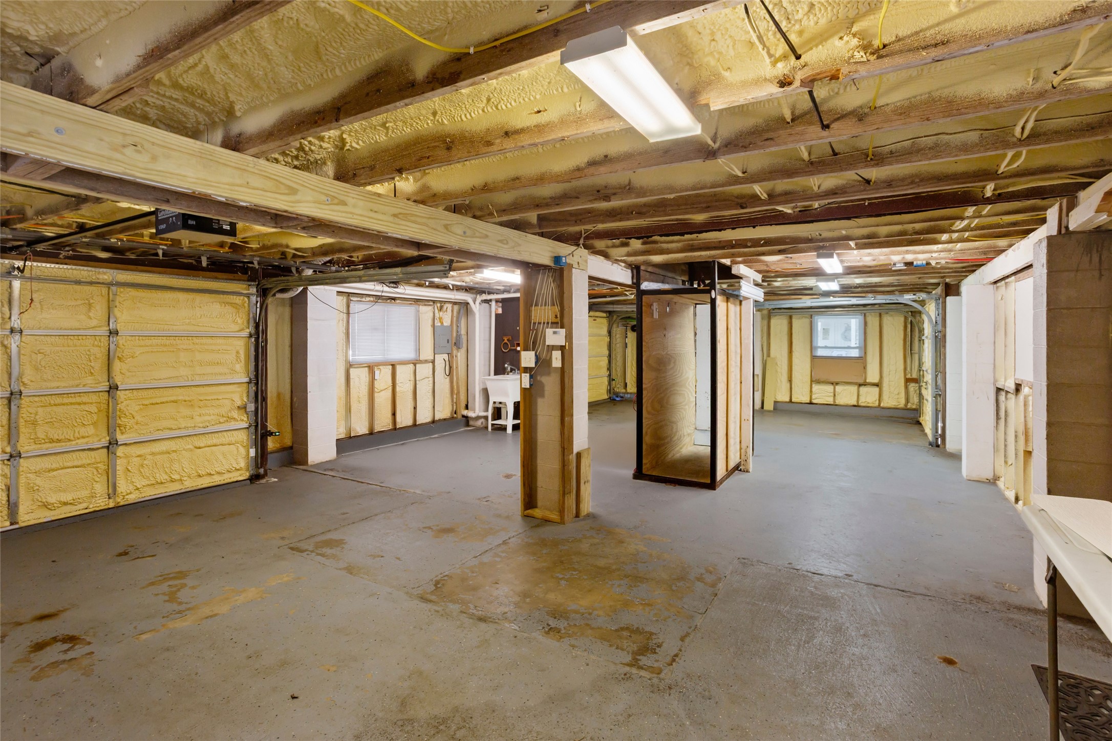 Expansive garage with dual front doors and a convenient rear door leading to the waterfront, ideal for storing fishing gear, golf carts, and jet skis.