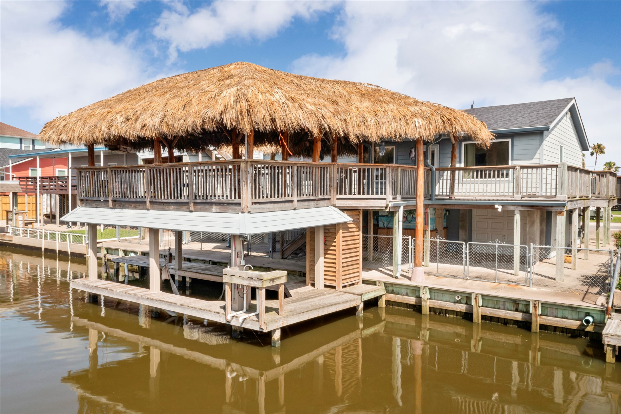 Experience waterfront living with this boathouse and amazing palapa bar, featuring a cozy natural gas fire pit and a TV enclosure for screens up to 45 inches. Enjoy ambient lighting with recessed and regular rope lighting, and built-in speaker connections for enhanced entertainment. Experience waterfront living with this boathouse and amazing palapa bar, featuring a cozy natural gas fire pit and a TV enclosure for screens up to 45 inches. Enjoy ambient lighting with recessed and regular rope lighting, and built-in speaker connections for enhanced entertainment.