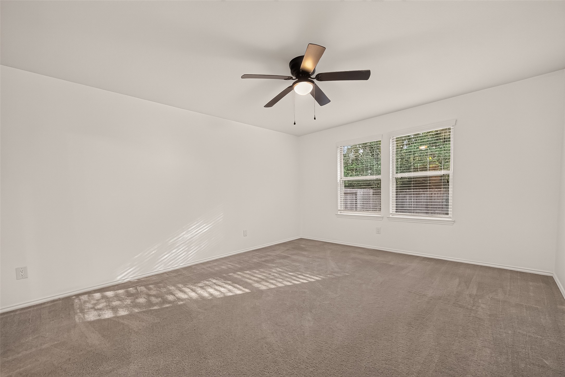 Spacious first floor primary bedroom featuring large windows that create an inviting atmosphere and enhance the rooms open, airy feel.