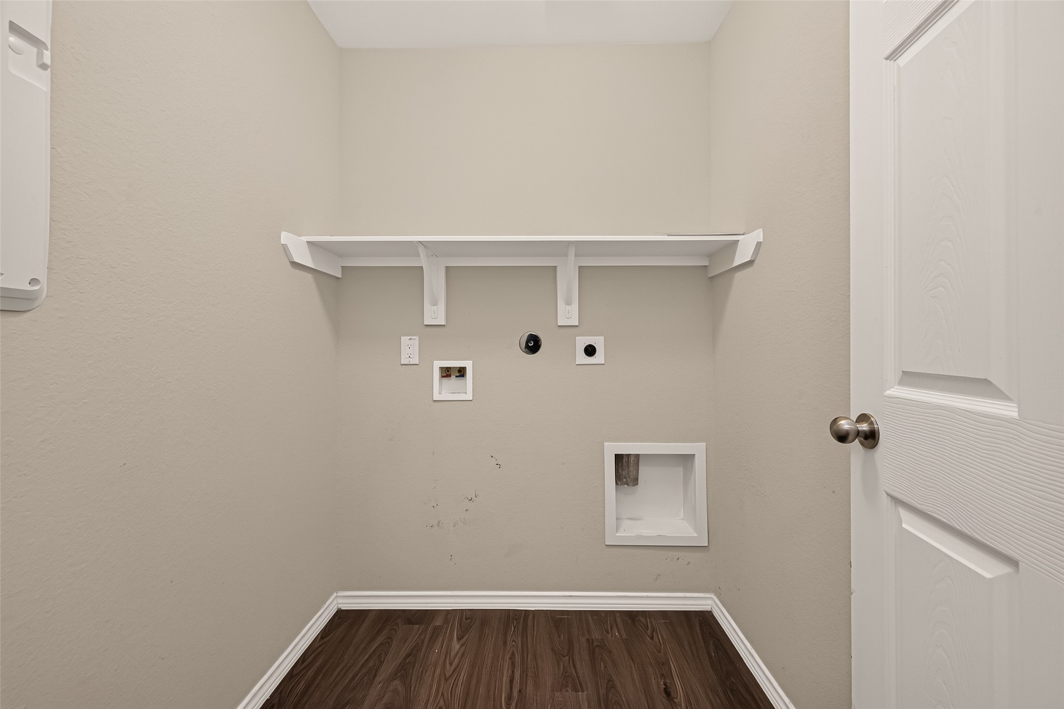 Functional laundry room featuring built-in shelving for added storage and organization, making everyday laundry routines more convenient and efficient