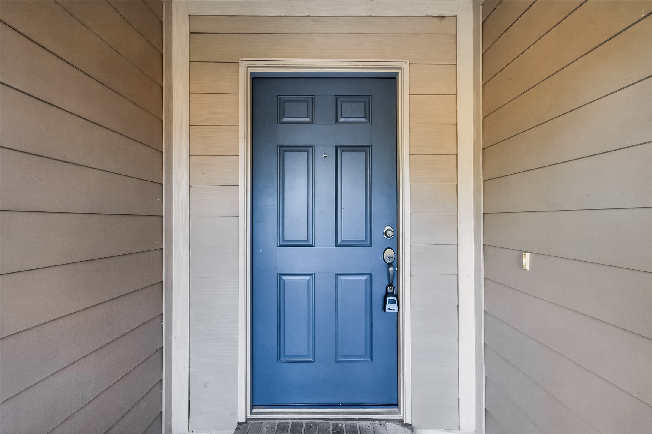 Stylish blue entry door adds a refreshing pop of color and personality, creating a welcoming first impression with distinctive charm and curb appeal.