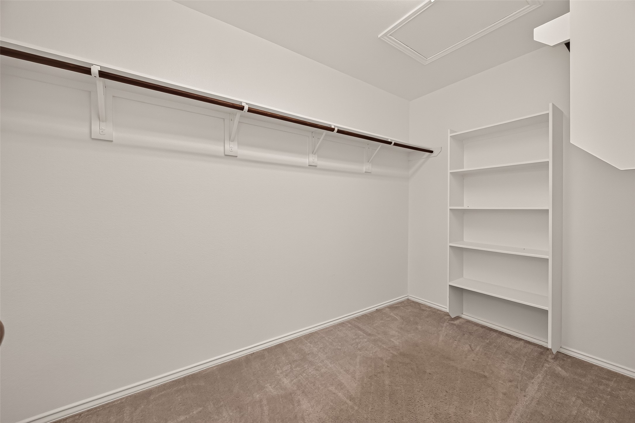 Expansive walk-in closet featuring built-in shelving and ample storage space, thoughtfully designed to keep your wardrobe and everyday essentials organized and easily accessible.