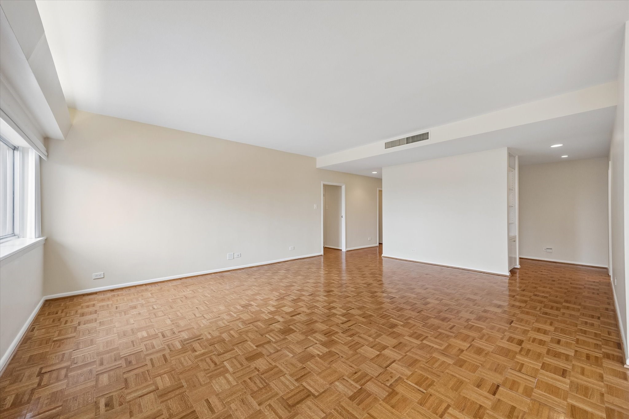 Large Living Room (16.5 x 21.5) with plantation shutters and parkay floors