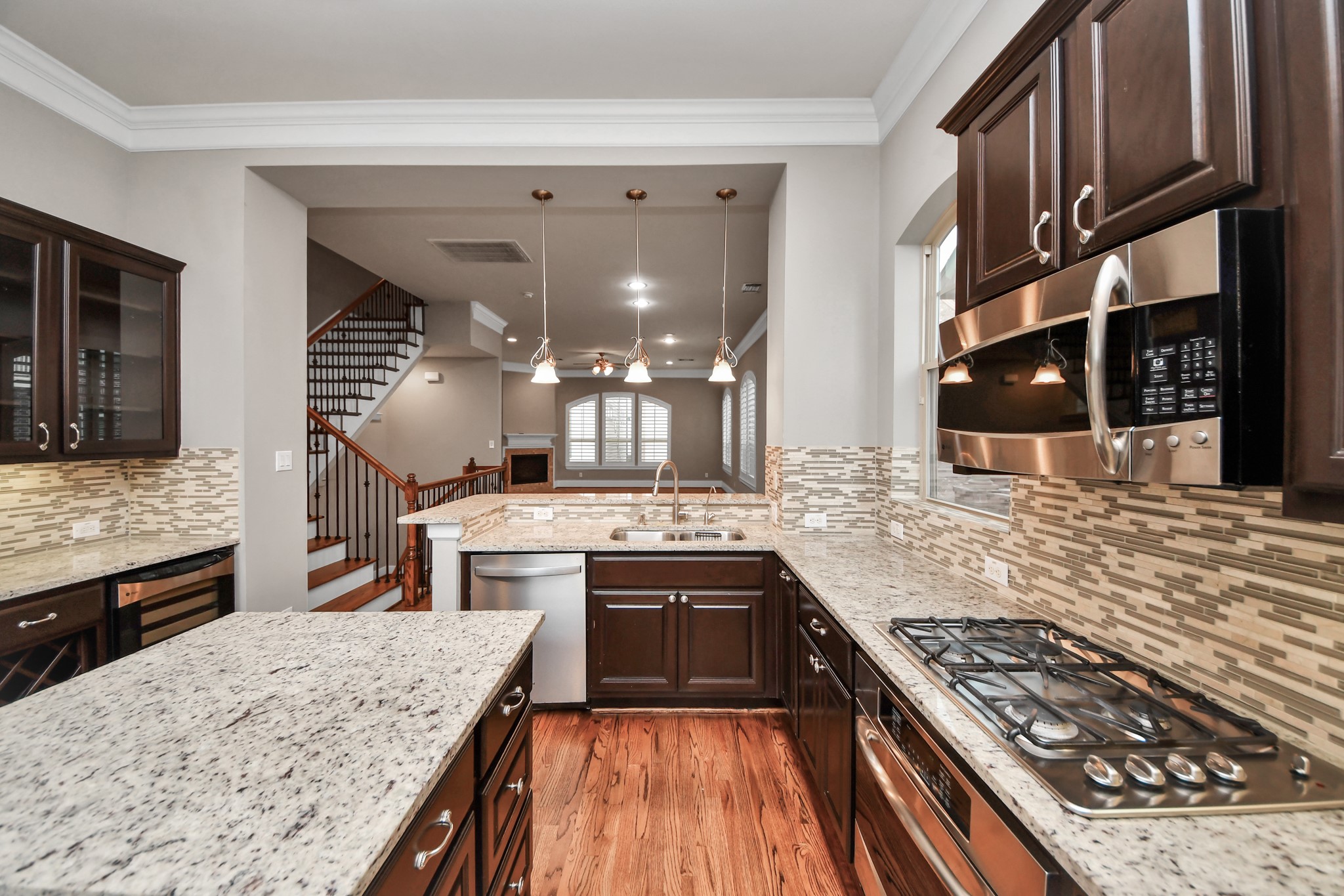 Gas cooktop, stainless steel appliances and granite countertops highlight this open kitchen.