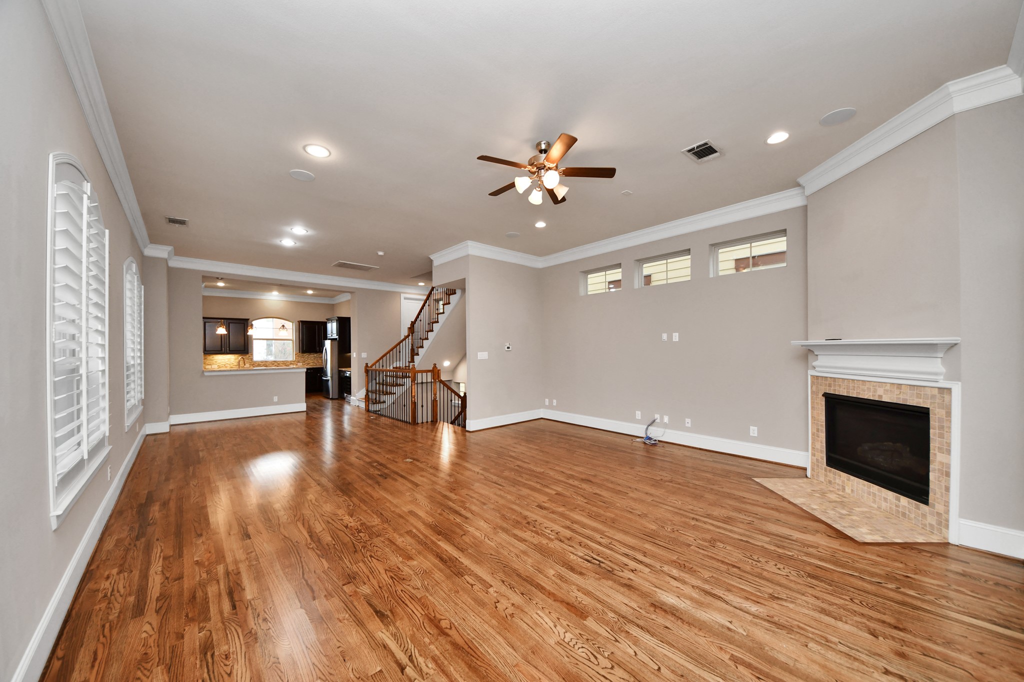 Another view of the spacious living room with hardwood floors, gas fire place, TONS of windows and a perfect area for your entertainment center!