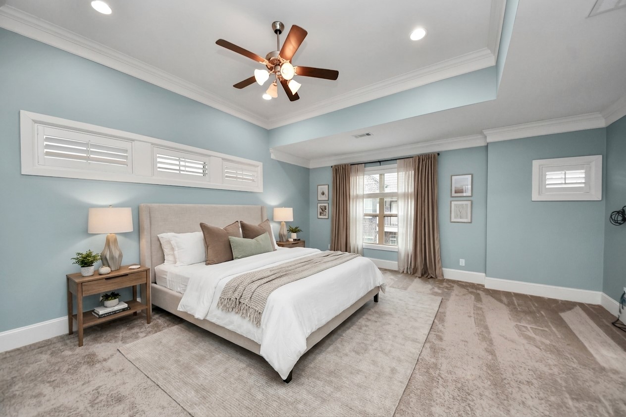Virtually Staged - Elegant primary bedroom offers a serene and spacious retreat with soft blue walls, abundant natural light, and stylish decor.