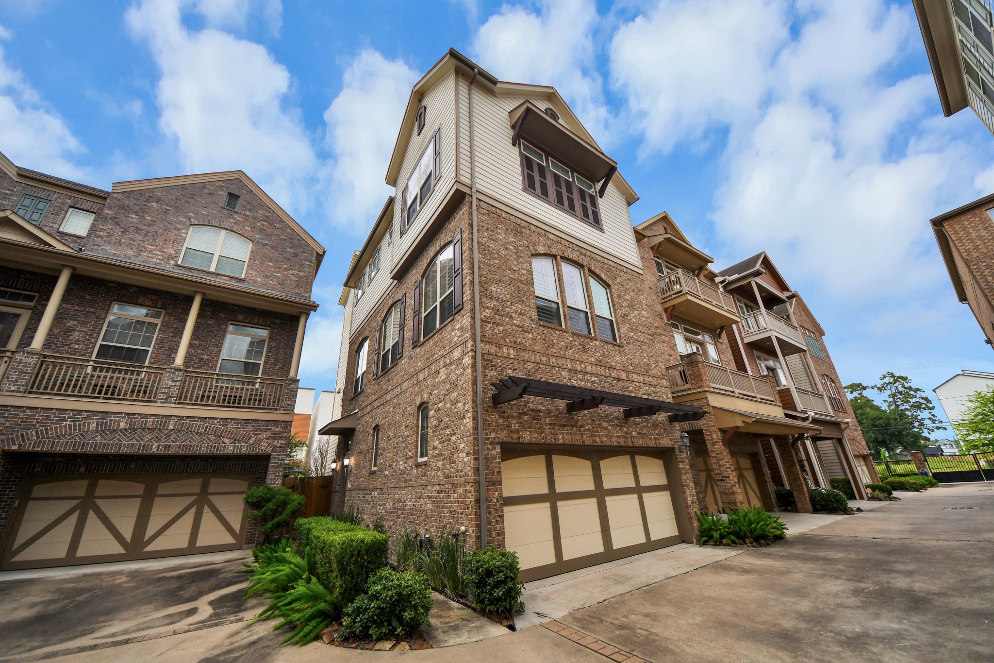 Charming three-story brick townhouse featuring abundant windows and a spacious two-car garage, nestled in a well-maintained community.