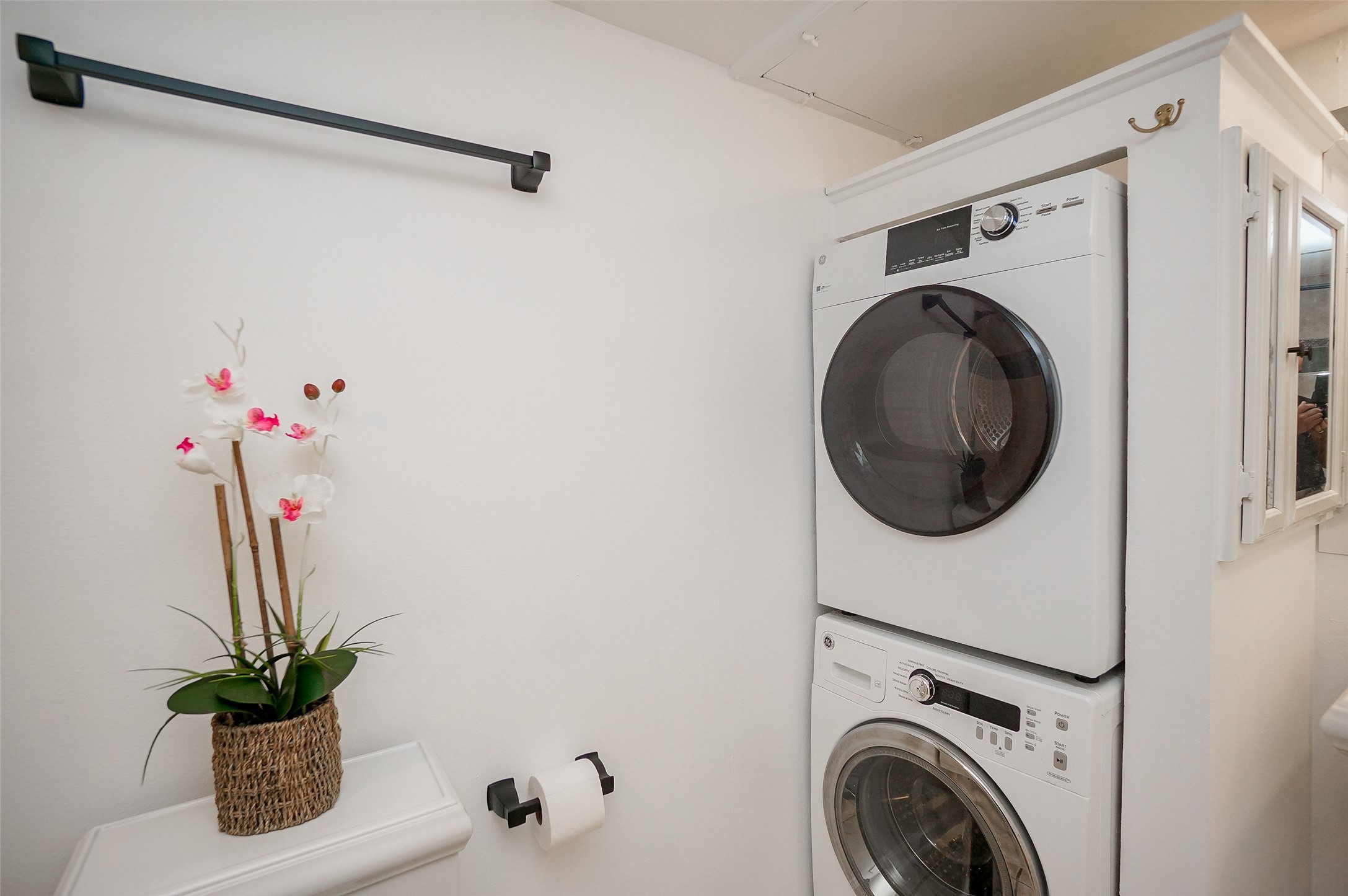 Washer and dryer are in the corner of the bathroom.