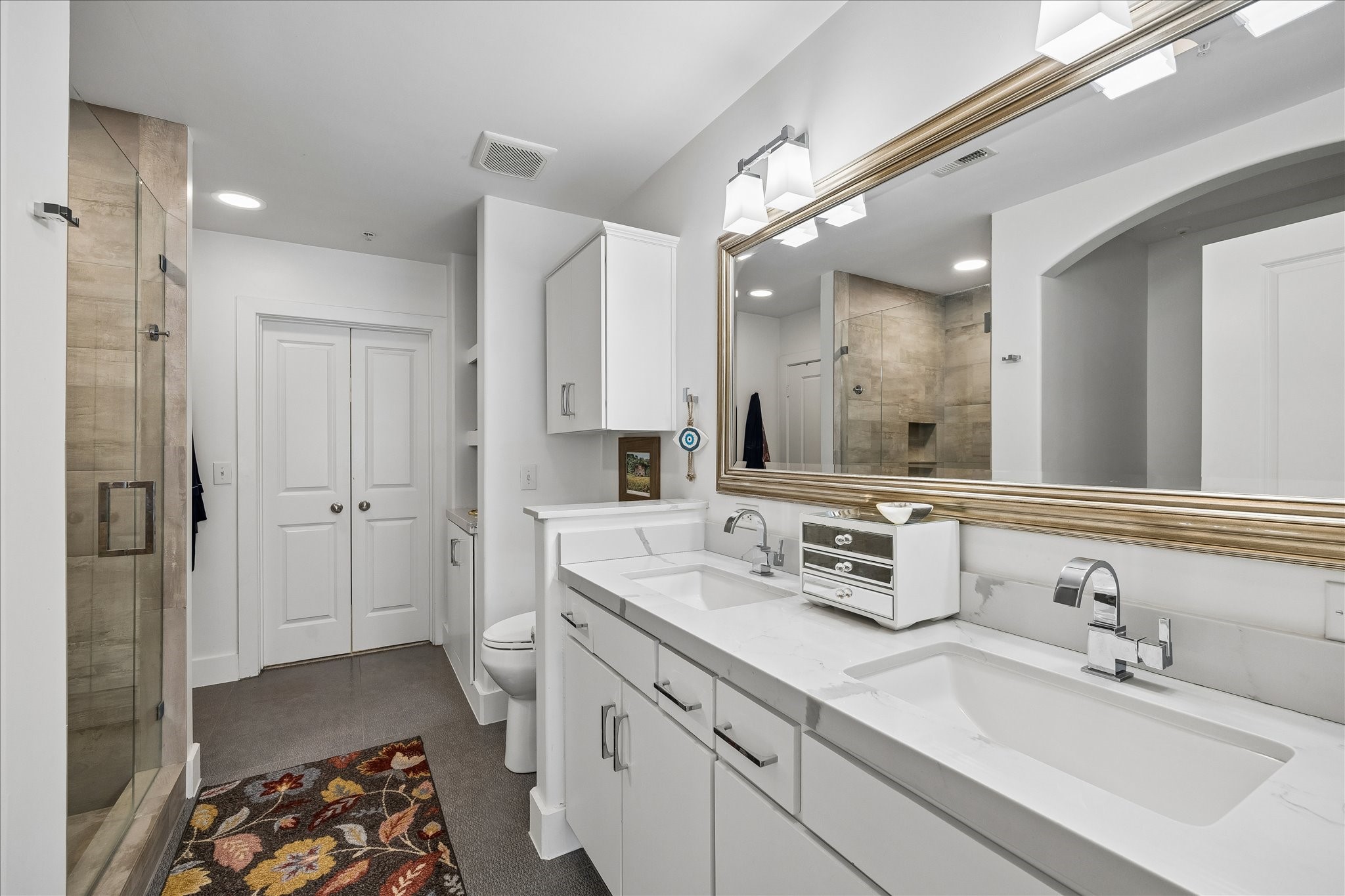 Designer touches, modern lighting, hardware and countertops with a frameless glass-enclosed shower.