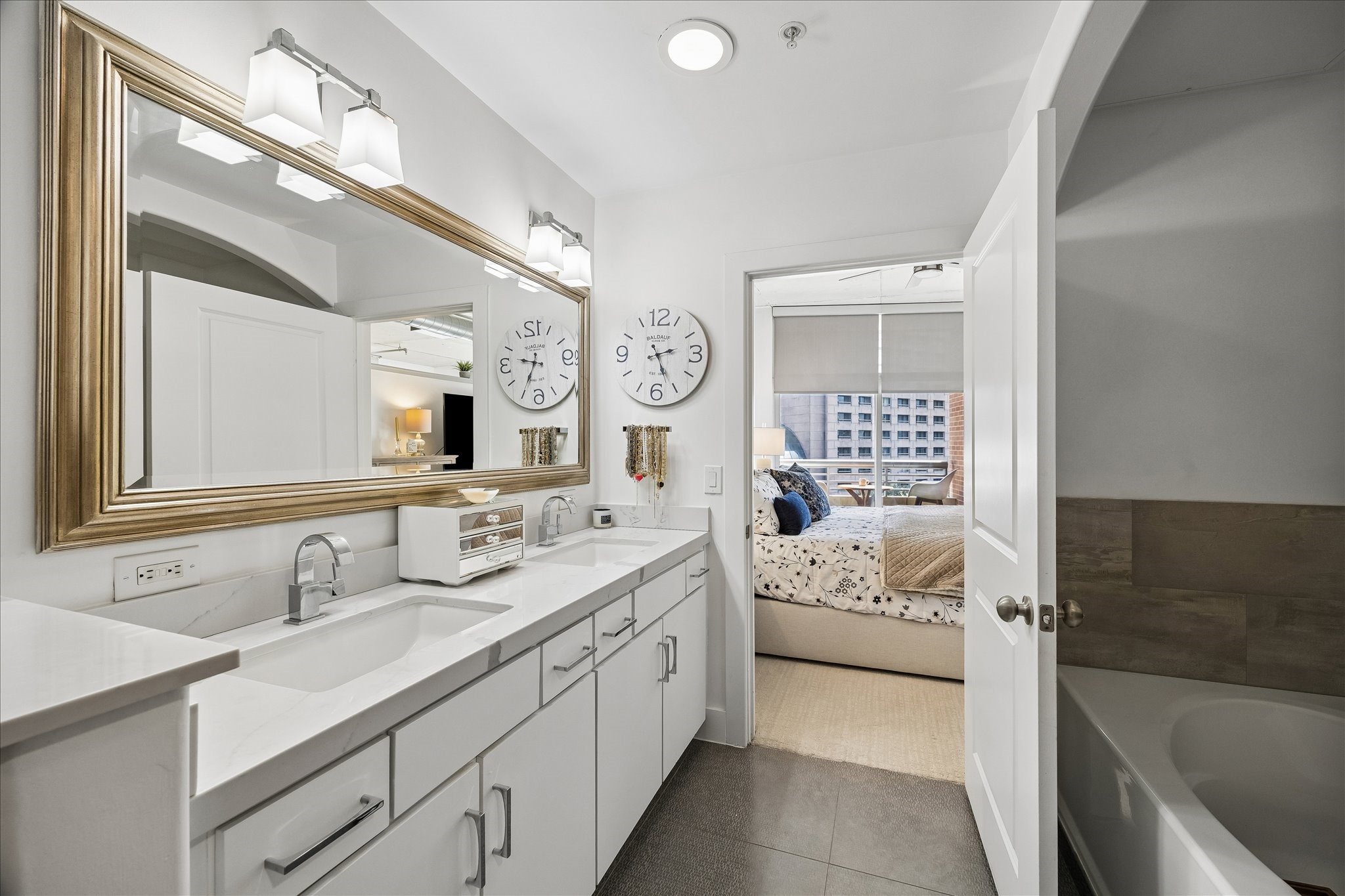 Elegant bathroom featuring a double vanity, updated tile and counters.  Featuring a soaking tub and separate shower.