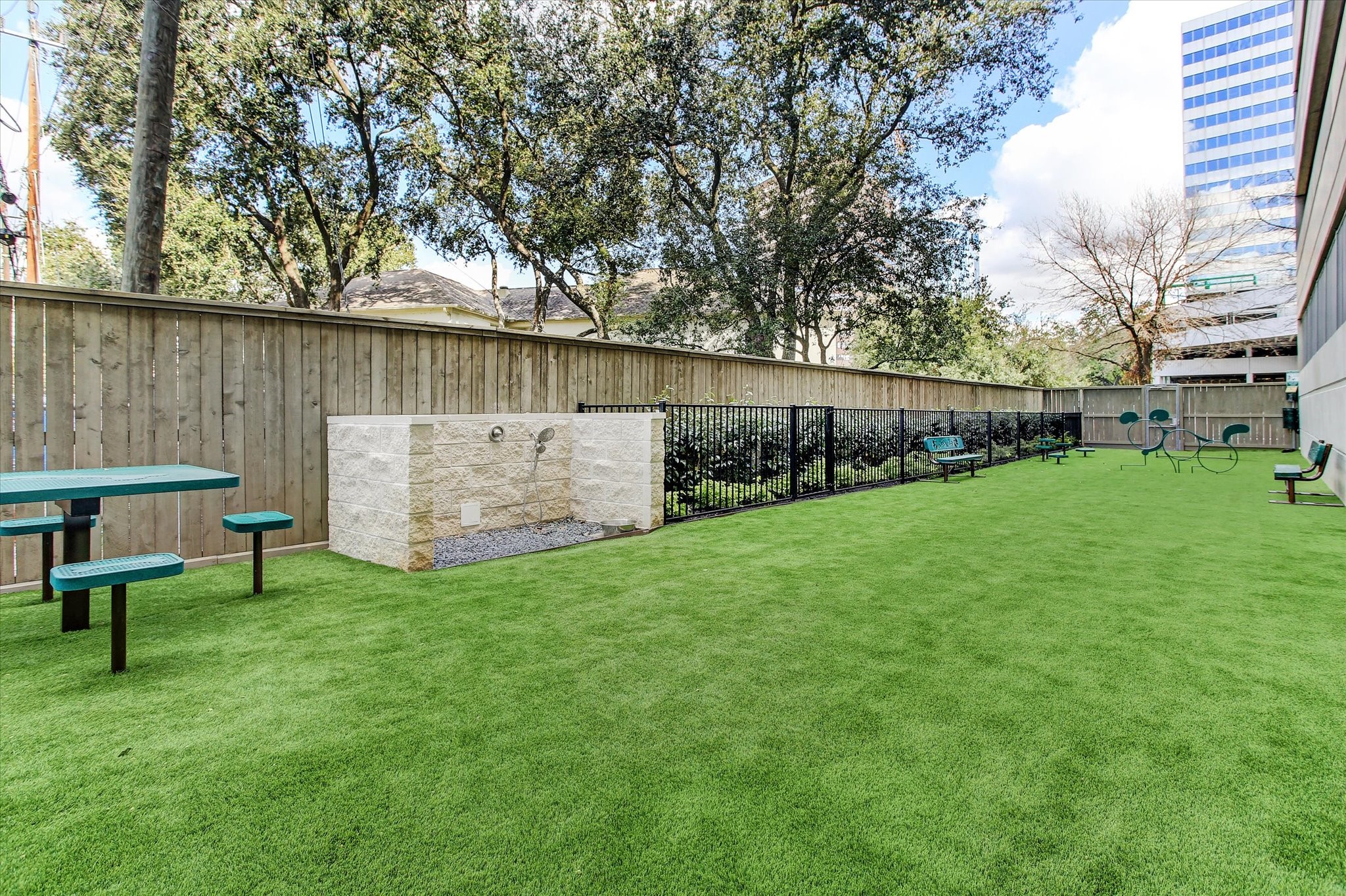 Enjoy a spacious outdoor area featuring lush green turf, perfect for the pups to use the dog washing station or make new friends.