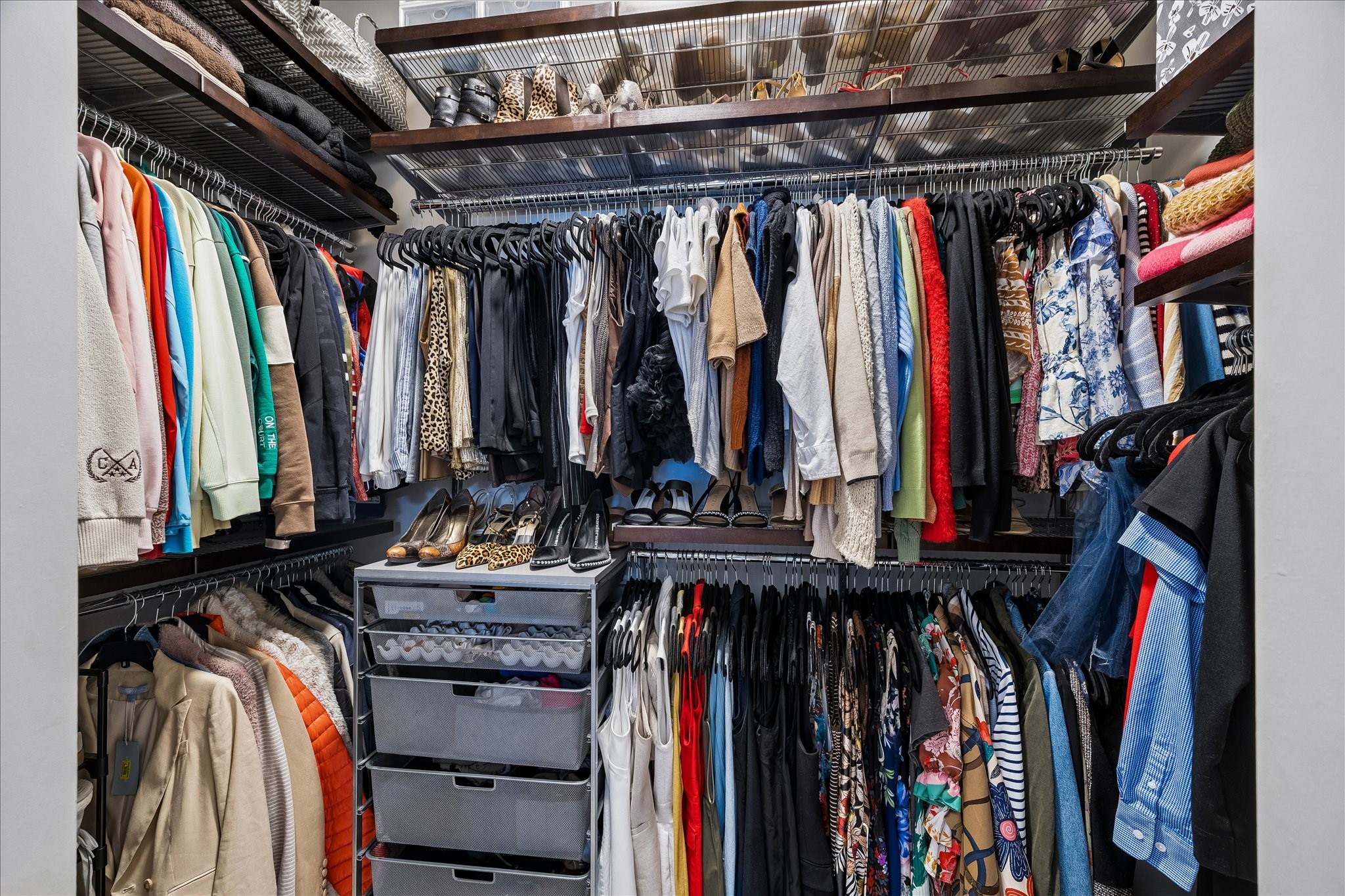 Spacious walk-in closet with abundant shelving and hanging space, perfect for organizing clothing and accessories.