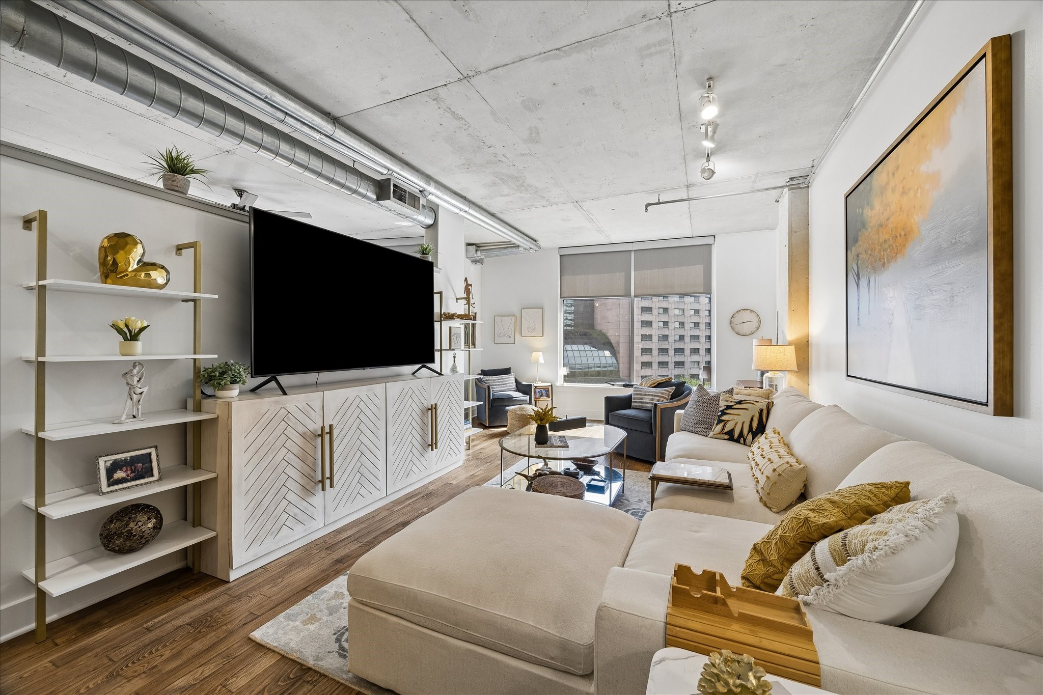 Large windows overlooking the esplanade, green space and trees.   White walls and large windows create a clean bright atmosphere.