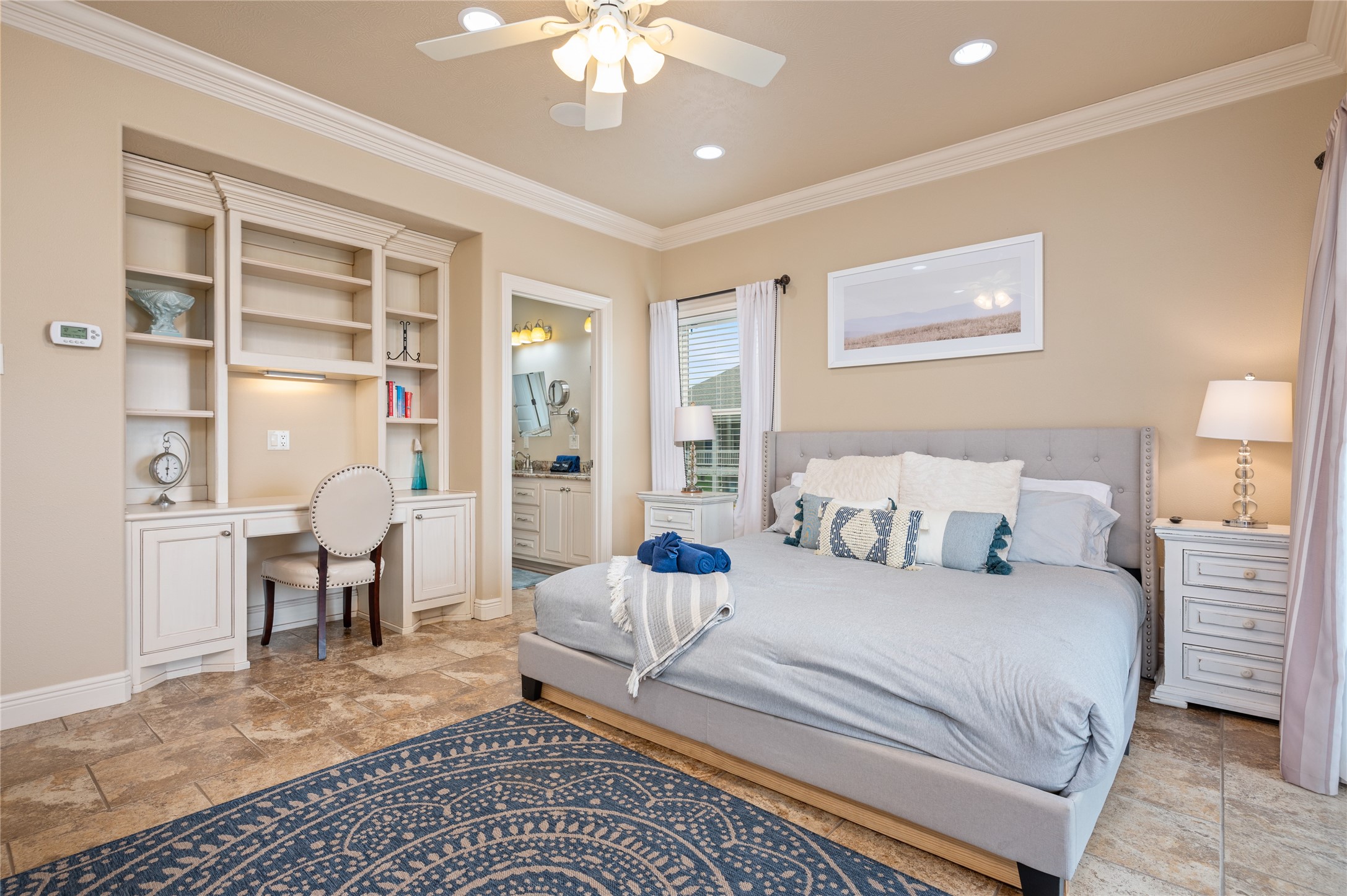 Unwind in your spacious primary bedroom with built-in workspace and storage, private bath access, and plenty of room to settle in comfortably.