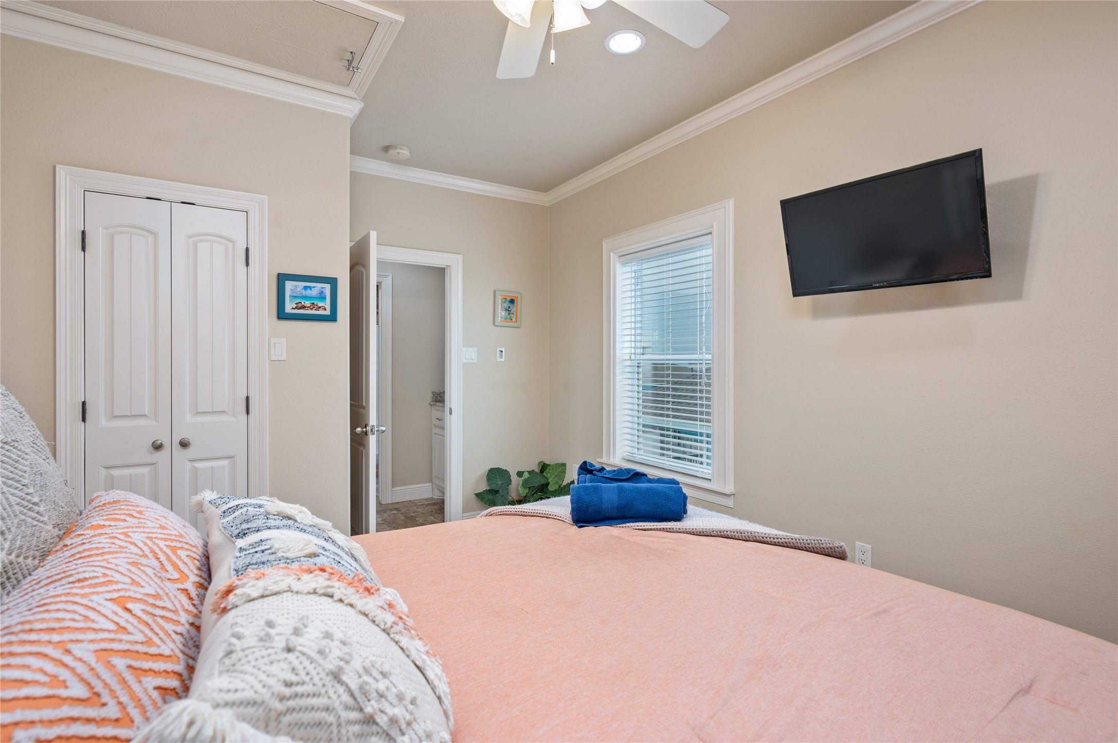 Wake up in this comfortable bedroom with a wall-mounted TV, crown molding, and your own private bath just steps away.