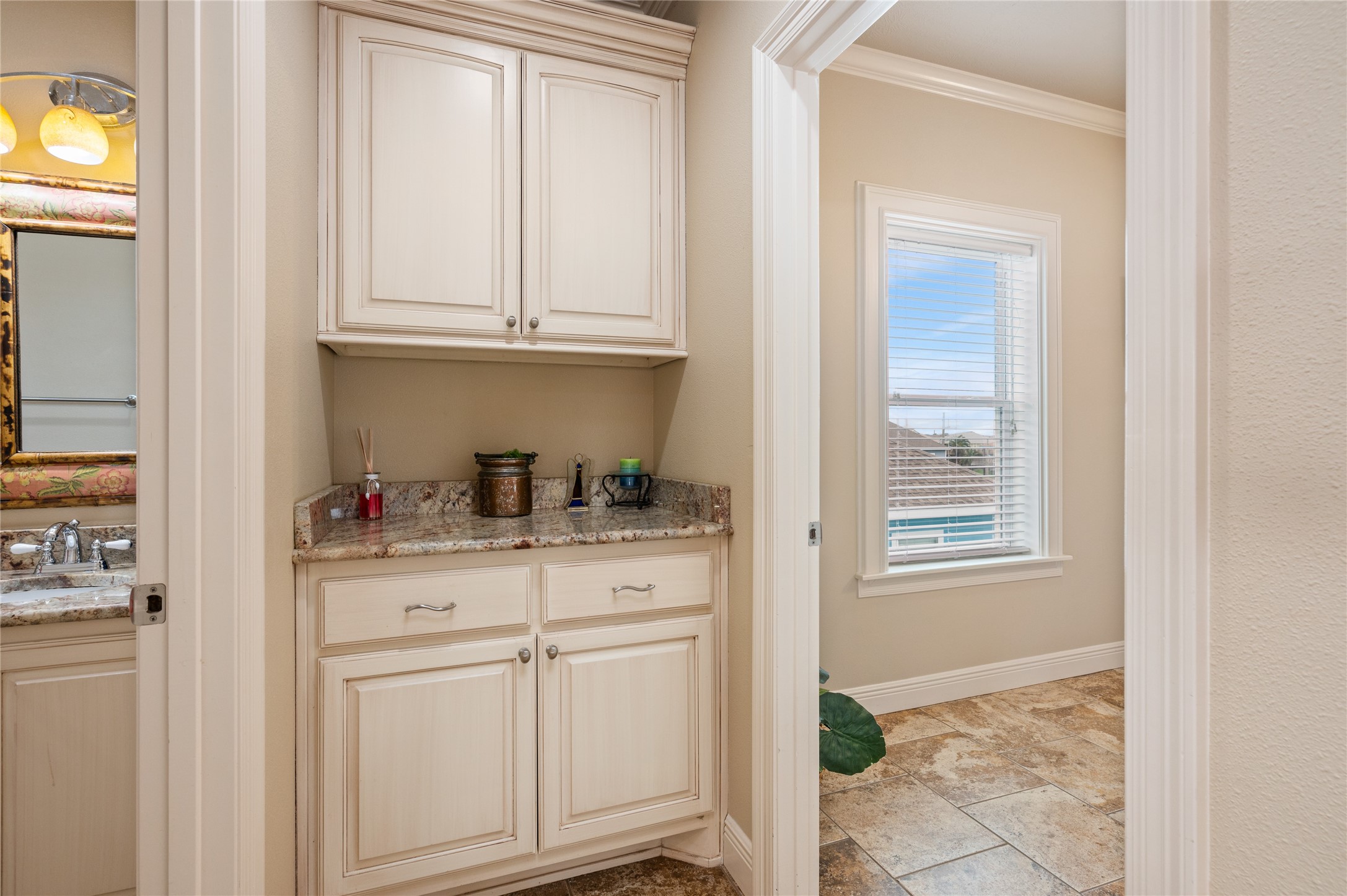 Extra built-in cabinetry and counter space just outside the bath give you a convenient spot to keep essentials organized and tucked away.