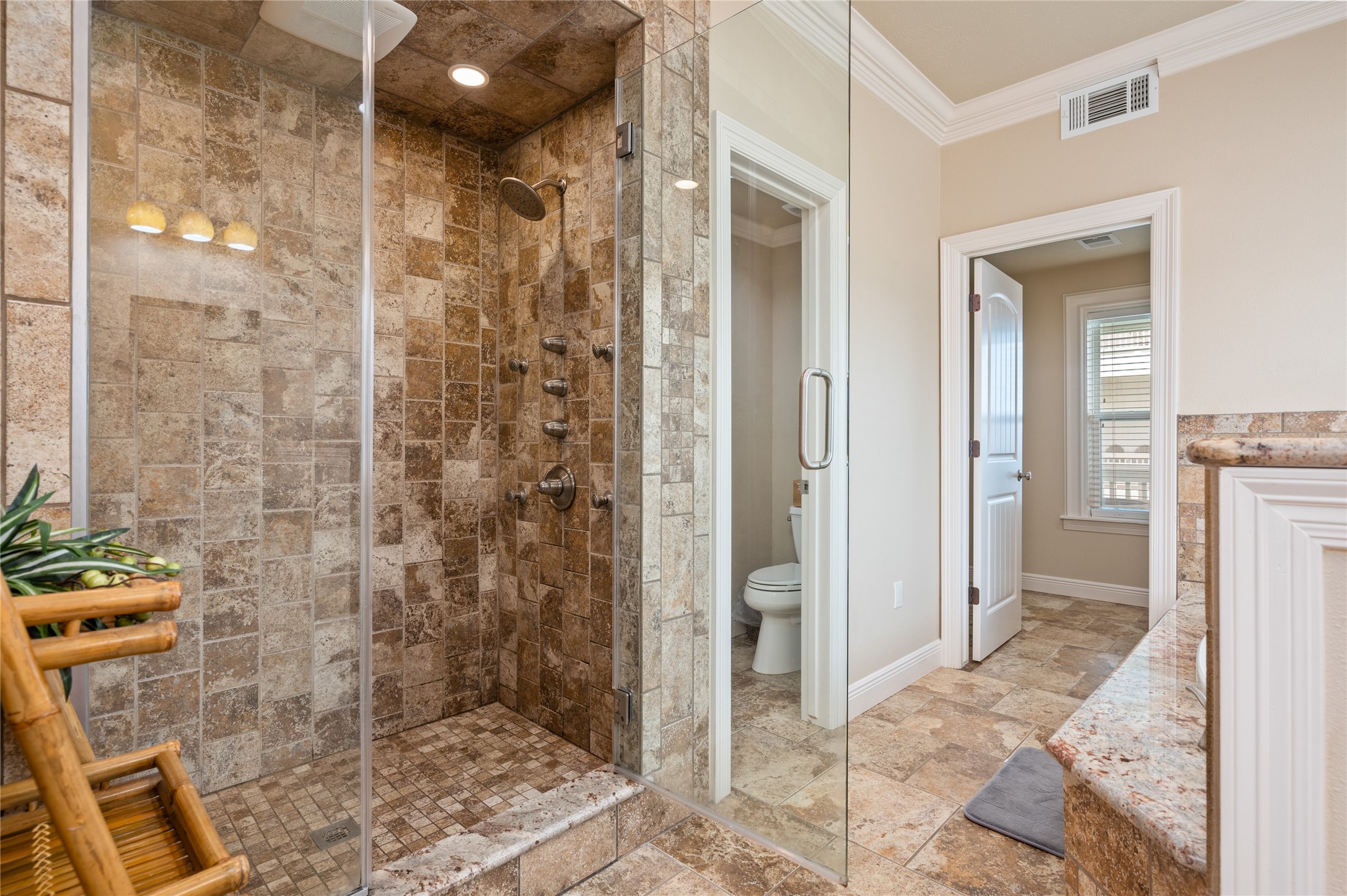 Step into your spacious tiled walk-in shower, complete with a frameless glass enclosure and multiple shower fixtures for a spa-like start to the day.