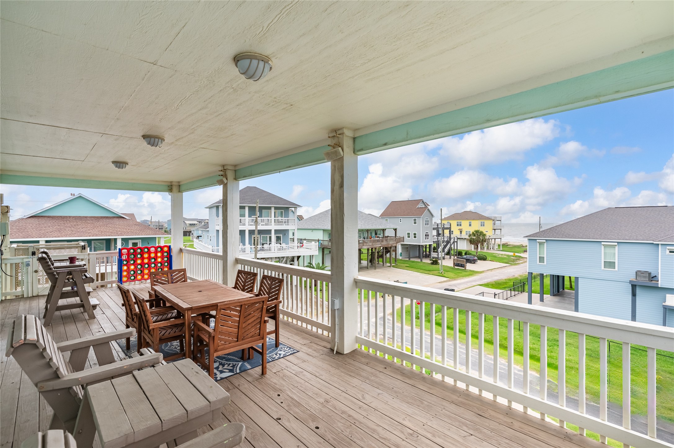 Morning coffee comes with a Gulf view from this spacious covered balcony, with plenty of room to dine, lounge, and enjoy the coastal breeze.