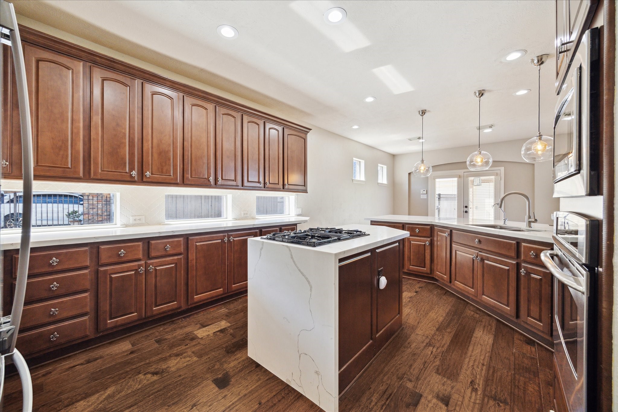 Custom kitchen cabinets with lots of natural light + downdraft gas stove