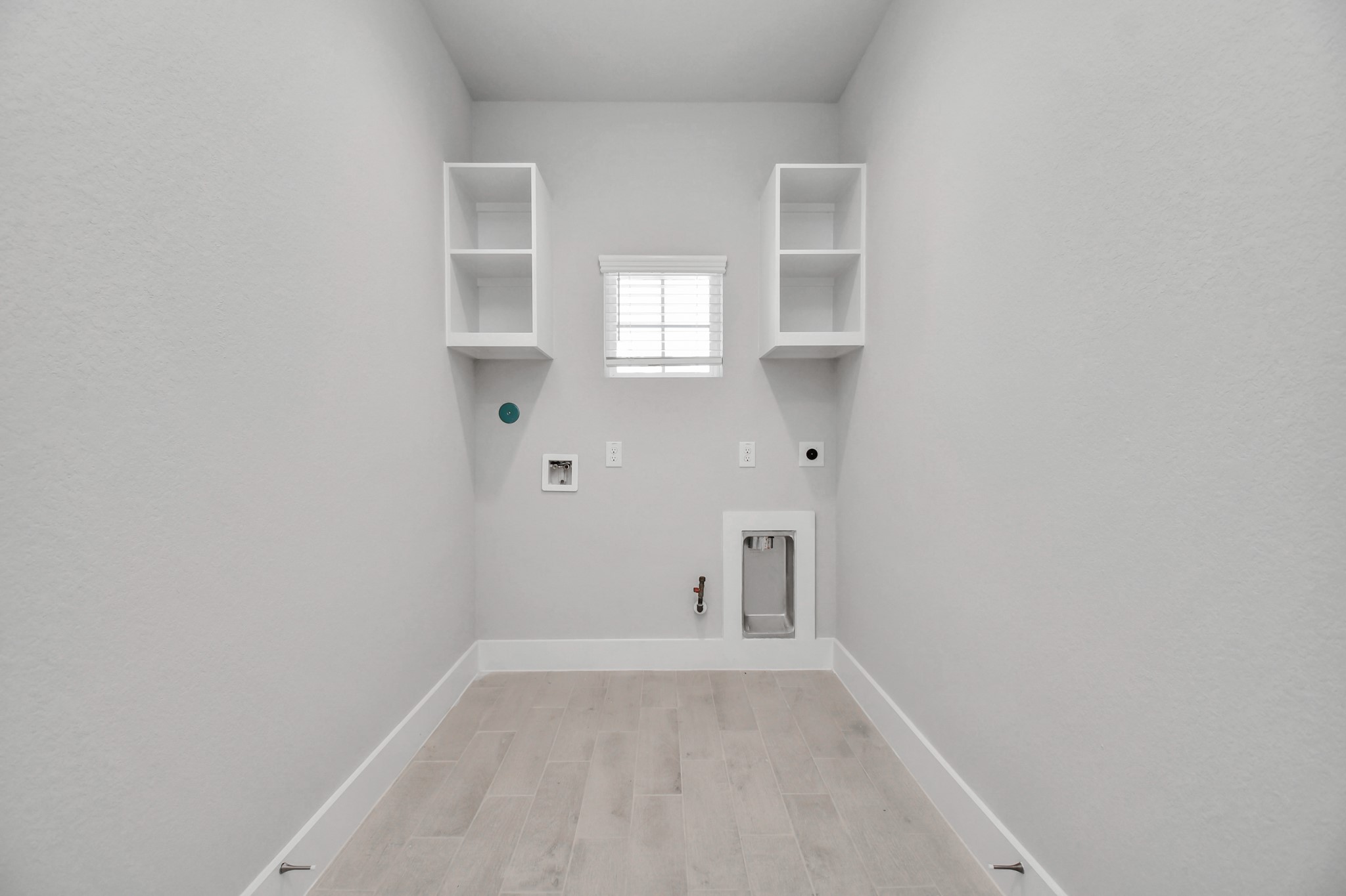 A perfect blend of functionality and comfort. Capture the essence of easy living with a first-floor laundry room, thoughtfully equipped with shelving for effortless organization. Both electric and gas connections available. Sample photo of completed home with similar floor plan. Actual colors and selections may vary.