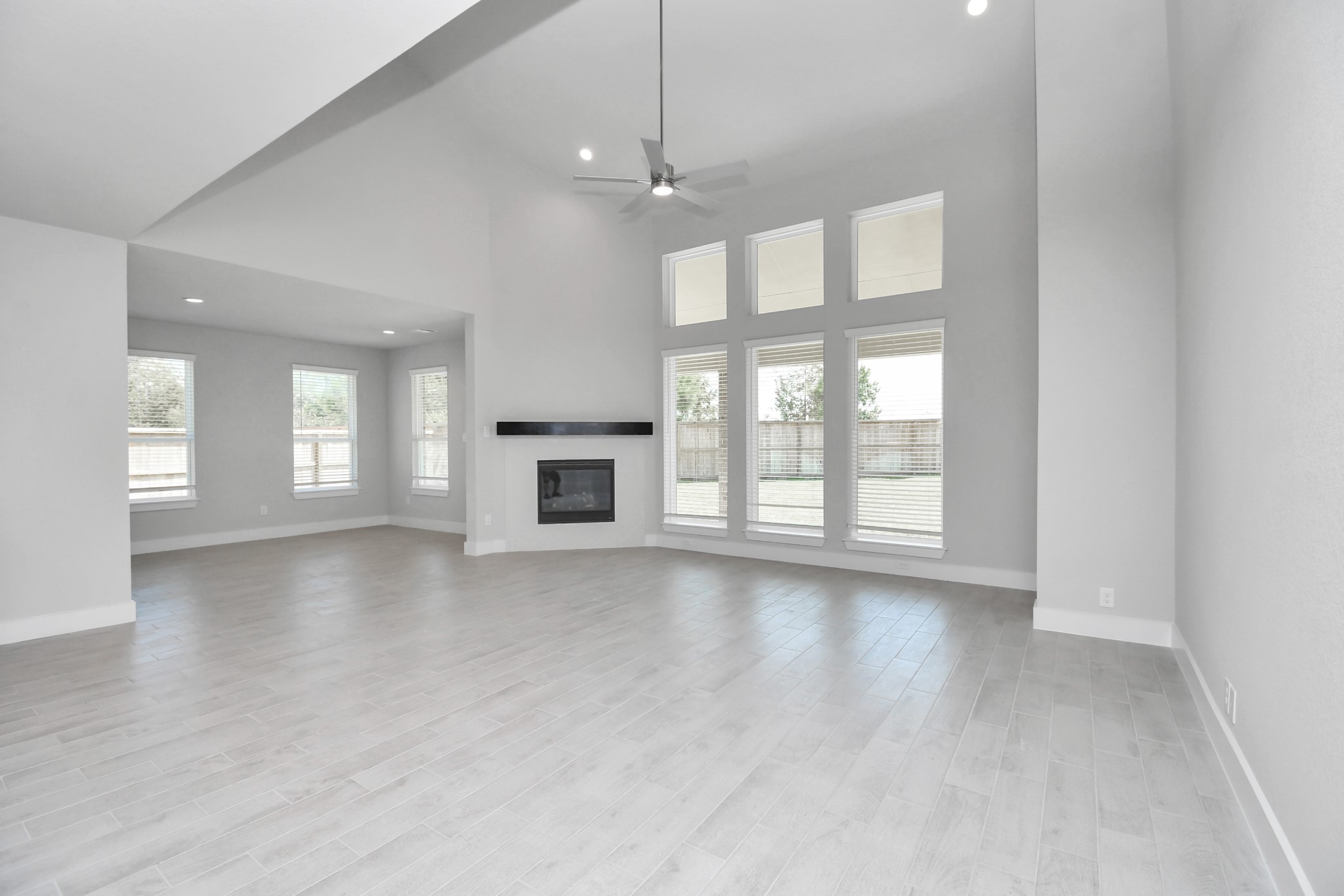 Welcome family and guests to your charming living room! With its high ceilings, recessed lighting, ceiling fan, custom paint, beautiful flooring, and large windows that let in abundant natural light, this room is perfect for gatherings. Sample photo of completed home with similar floor plan. Actual colors and selections may vary.