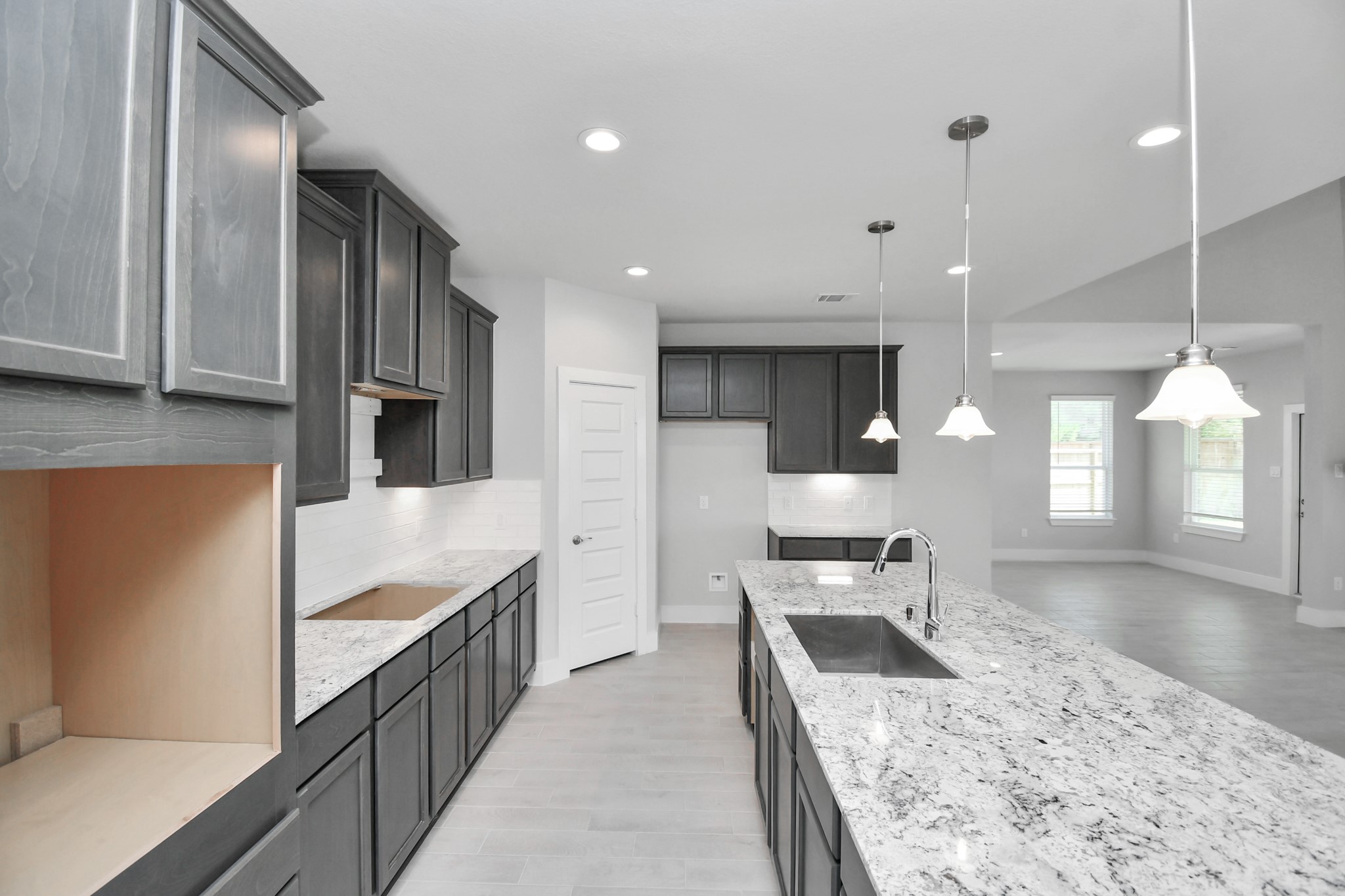 This kitchen is by far any chefs dream! This spacious kitchen features high ceilings, stained wood cabinets, granite countertop, SS appliances, modern tile backsplash, recessed lighting, extended counter space, granite kitchen island with double sink, and space for breakfast bar, and a walk-in pantry all overlooking your huge family room. Sample photo of completed home with similar floor plan. Actual colors and selections may vary.