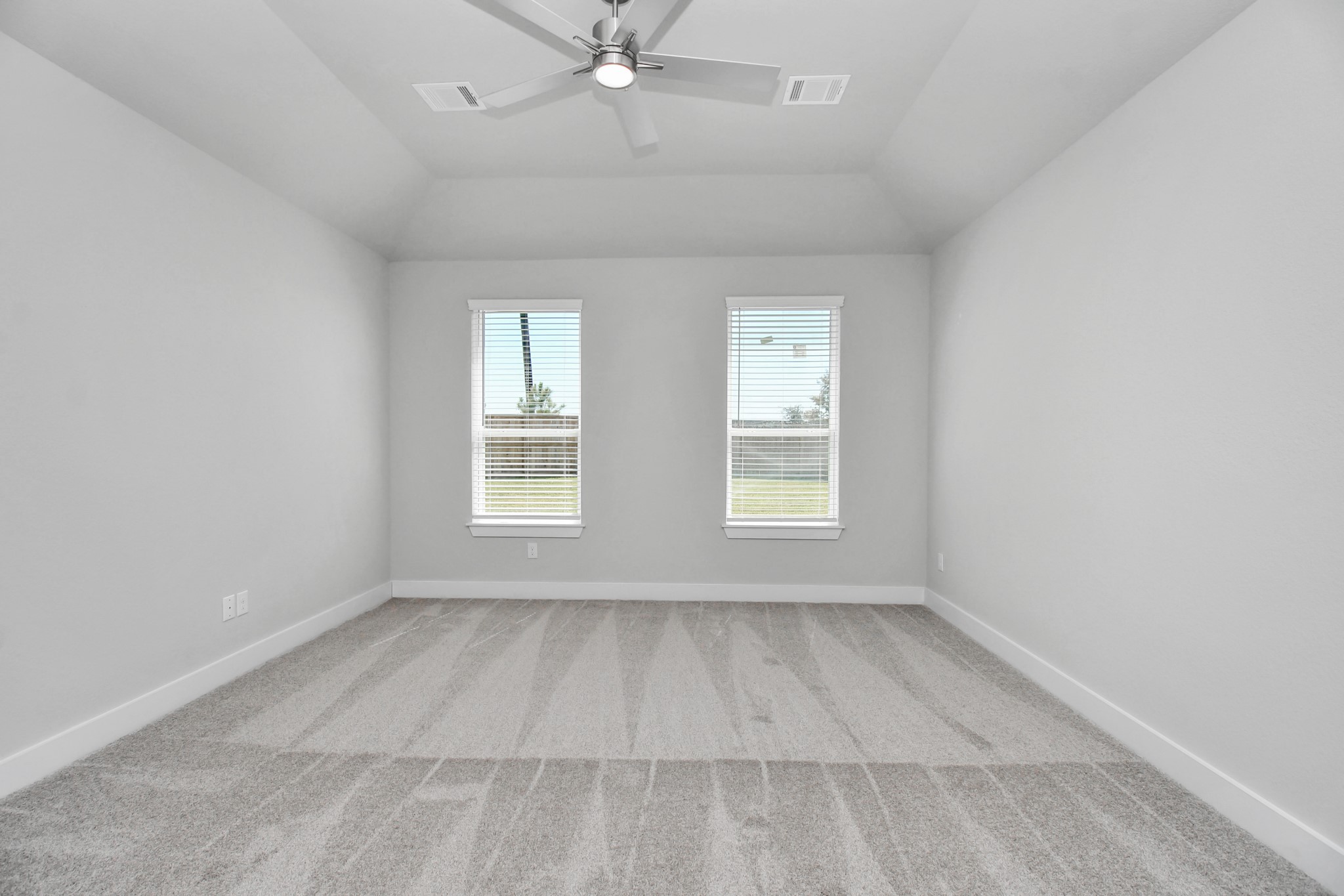 Escape to tranquility in this spacious primary room, adorned with plush carpeting and bathed in the soothing hues of warm paint colors, creating a cozy retreat for relaxation. Sample photo of completed home with similar floor plan. Actual colors and selections may vary.