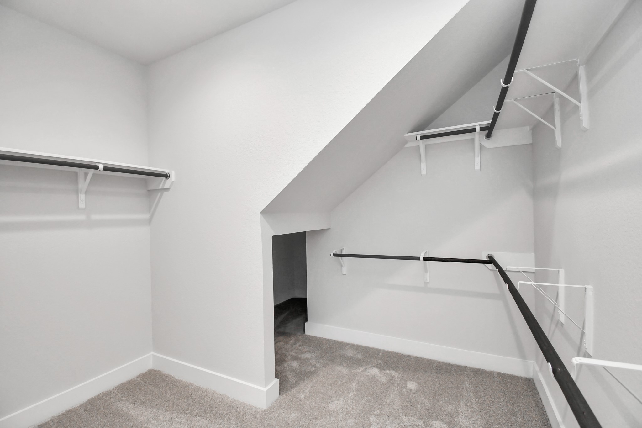 Walk-in closet that epitomizes luxury and practicality. This generously sized space features built-in shelving, offering abundant room for impeccable organization. High ceilings and recessed lighting create a bright and welcoming ambiance. Sample photo of completed home with similar floor plan. Actual colors and selections may vary.
