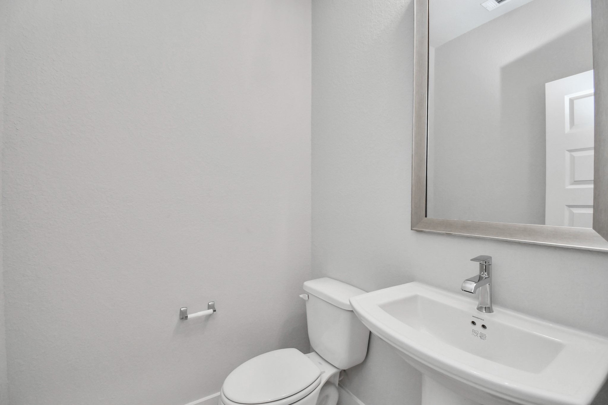 This half bathroom features a stylish pedestal sink, modern hardware, and bright recessed lighting, creating a sleek and inviting space. Sample photo of completed home with similar floor plan. Actual colors and selections may vary.