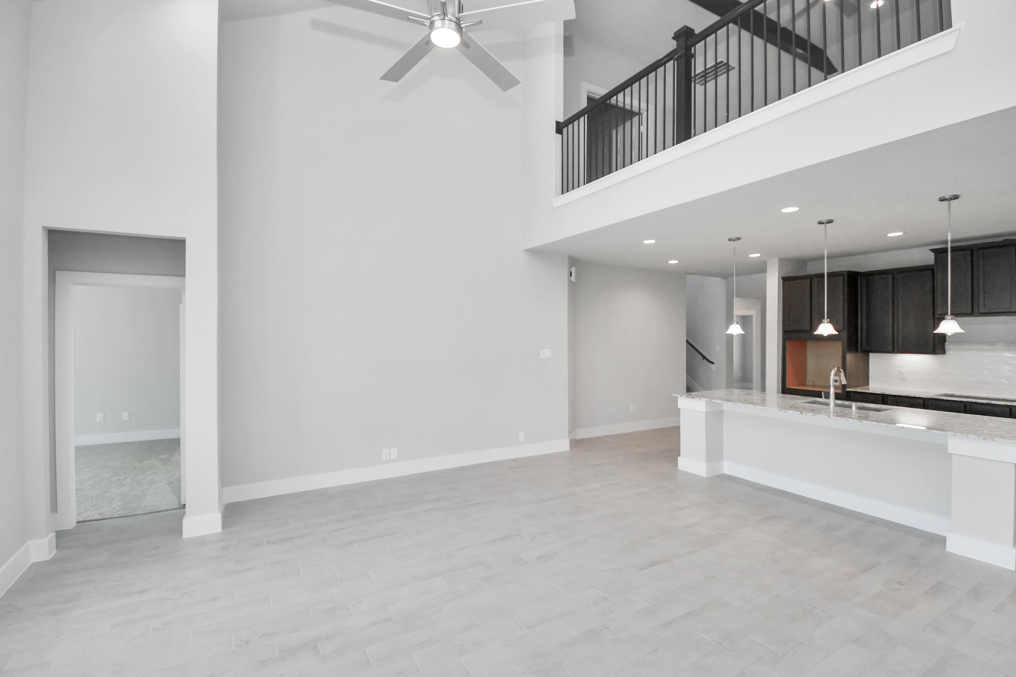 Family room flooded with natural light through the expansive windows.  The premium tile flooring adds a touch of luxury to the space, creating the perfect setting for relaxing moments and cherished gatherings with loved ones Sample photo of completed home with similar floor plan. Actual colors and selections may vary.