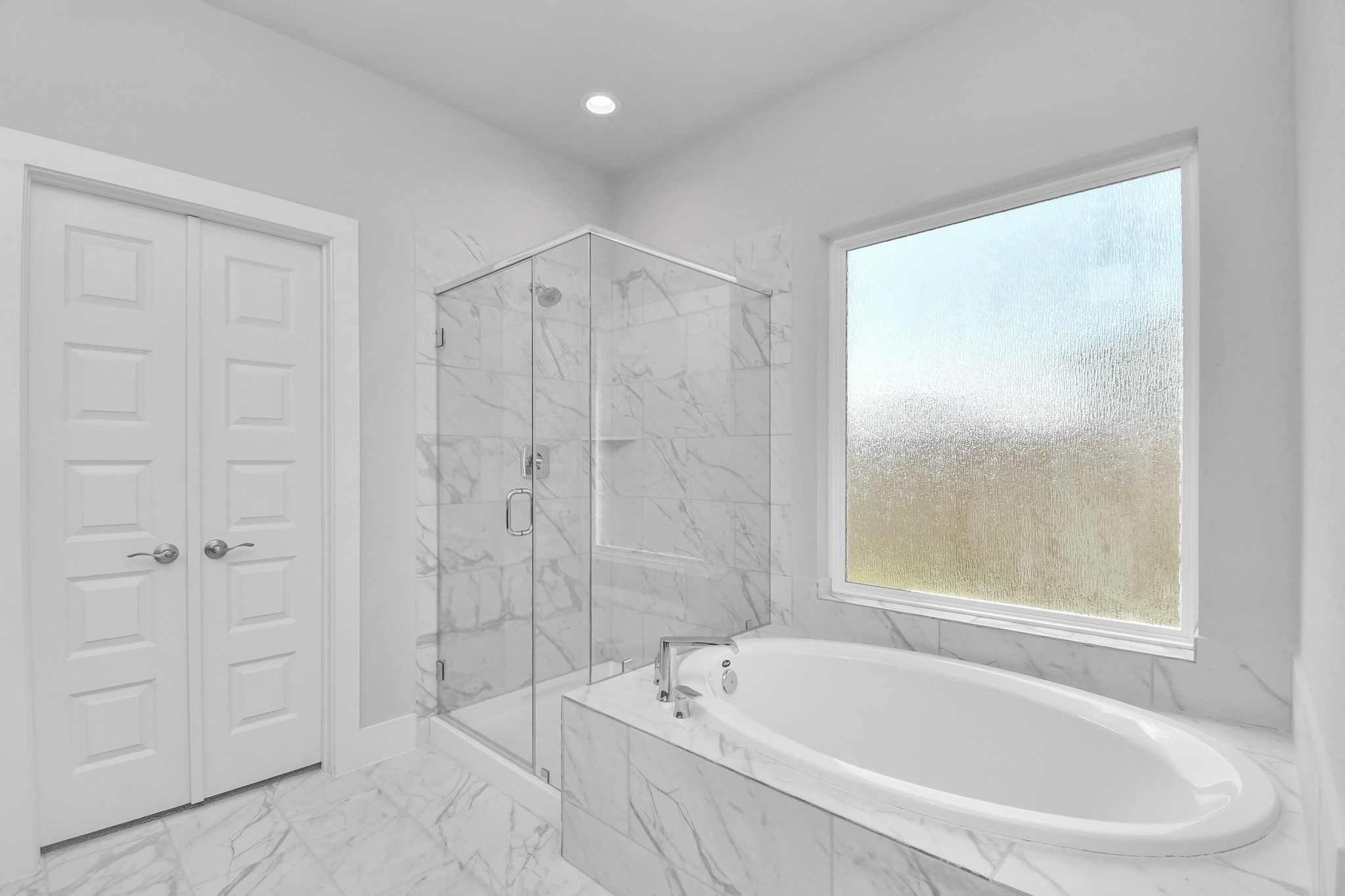 Indulge in a spa-like retreat within the confines of this primary bathroom. Delight in a spacious walk-in shower enveloped in stylish tile surround and unwind in a separate garden tub adorned with custom detailing. Sample photo of completed home with similar floor plan. Actual colors and selections may vary.